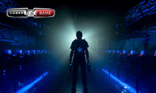 personne en habits de laser game qui est posté devant une lumière blanche dans un couloir noir.