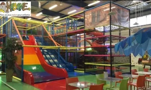 Centre de loisir pour enfants avec des activités de grimpe, de sauts, de filets et de toboggans.