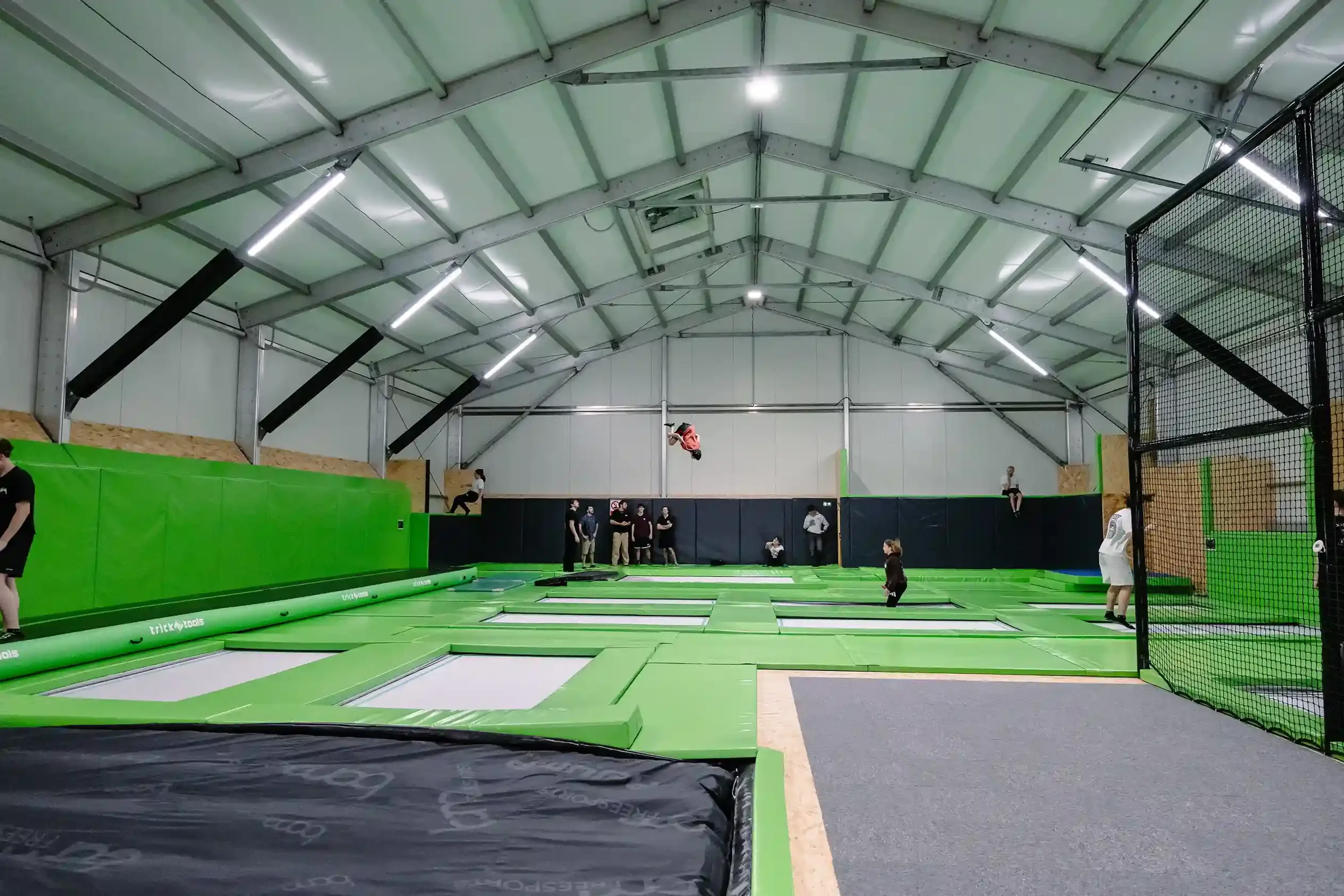 Photo de l'intérieur de la salle de trampoline BAM FREESPORTS Annecy, il y a des jeunes qui sautent sur les différents trampolines de la salle