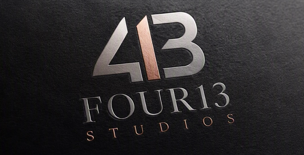 Logo of Four13 Studios featuring the number 413 with the number 4 and 3 in silver and the 1 in a copper color, with the words "FOUR13 STUDIOS" written below on a black textured background.