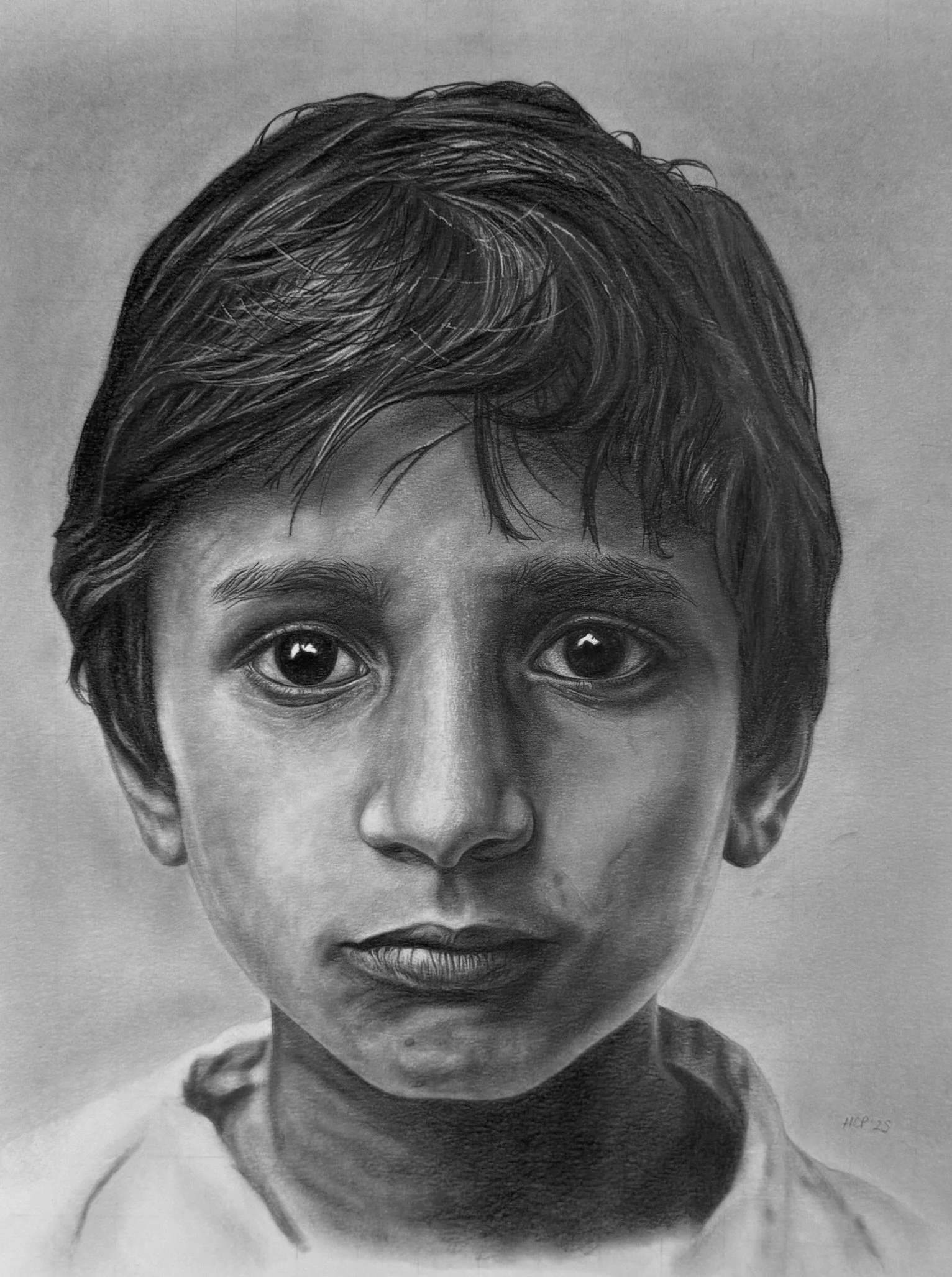 A detailed black and white portrait of a young boy with short, tousled hair, expressive eyes, and a neutral facial expression.