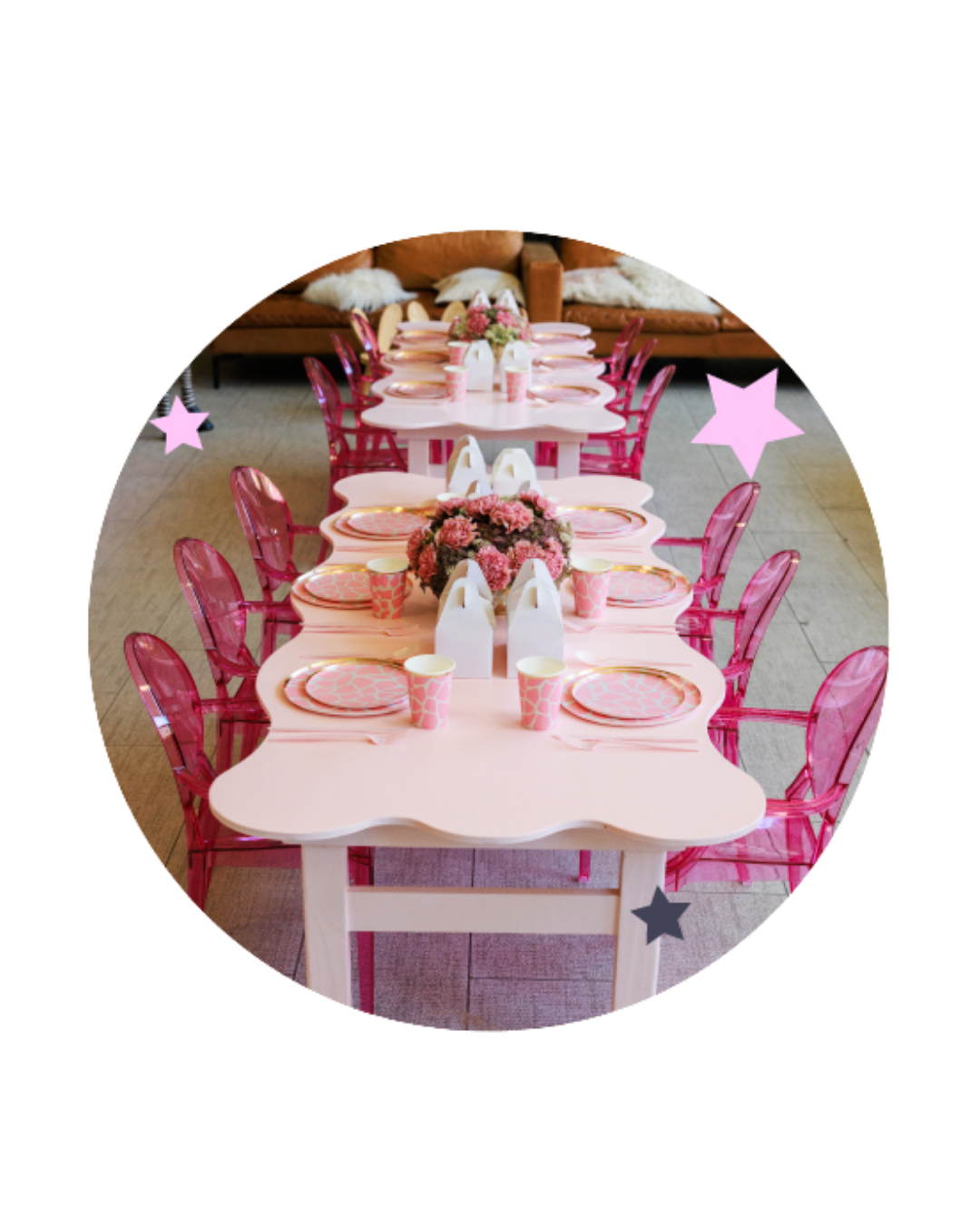 A pink and white children's birthday party table set with pink plates, cups, and napkins, decorated with pink flowers and surrounded by transparent pink chairs.