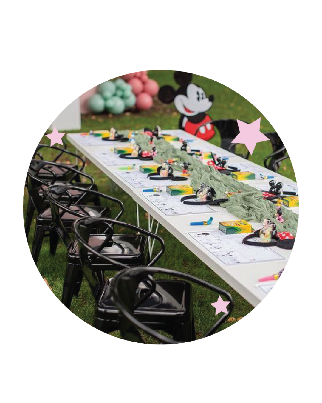Party table decorated with Mickey Mouse themed items and a Mickey Mouse balloon sculpture in the background.