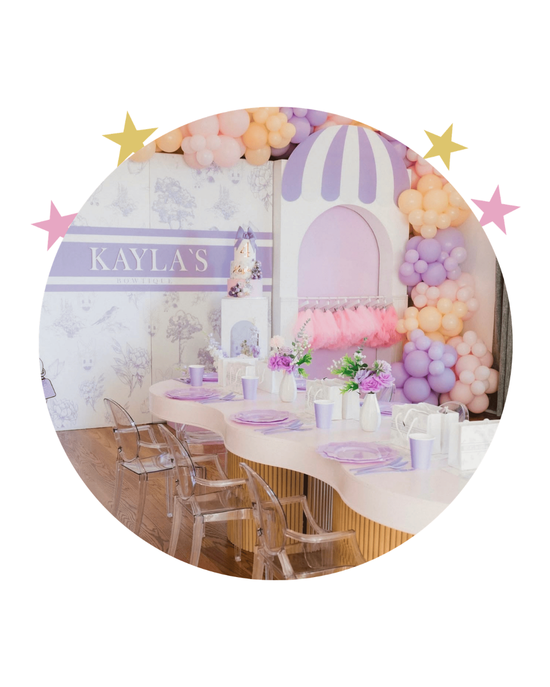 Decorated birthday party table with pink and purple balloons, floral centerpieces, and a backdrop with the name 'Kayla's Bou-tique'