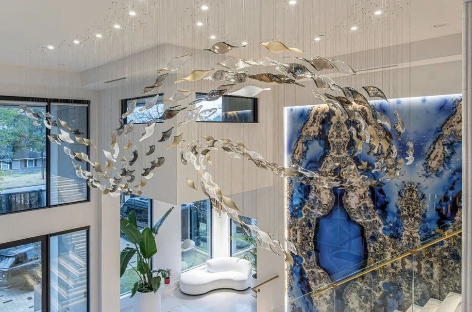 Sculptural suspended lighting displayed above a dramatic blue stone feature in a contemporary interior.
