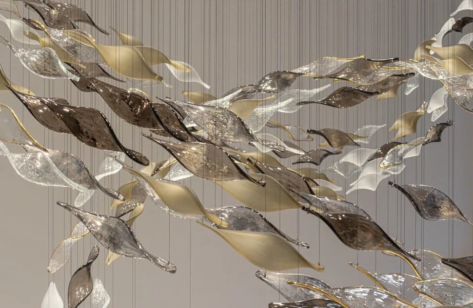 Close view of layered silver and bronze sculptural forms creating an organic ceiling installation.