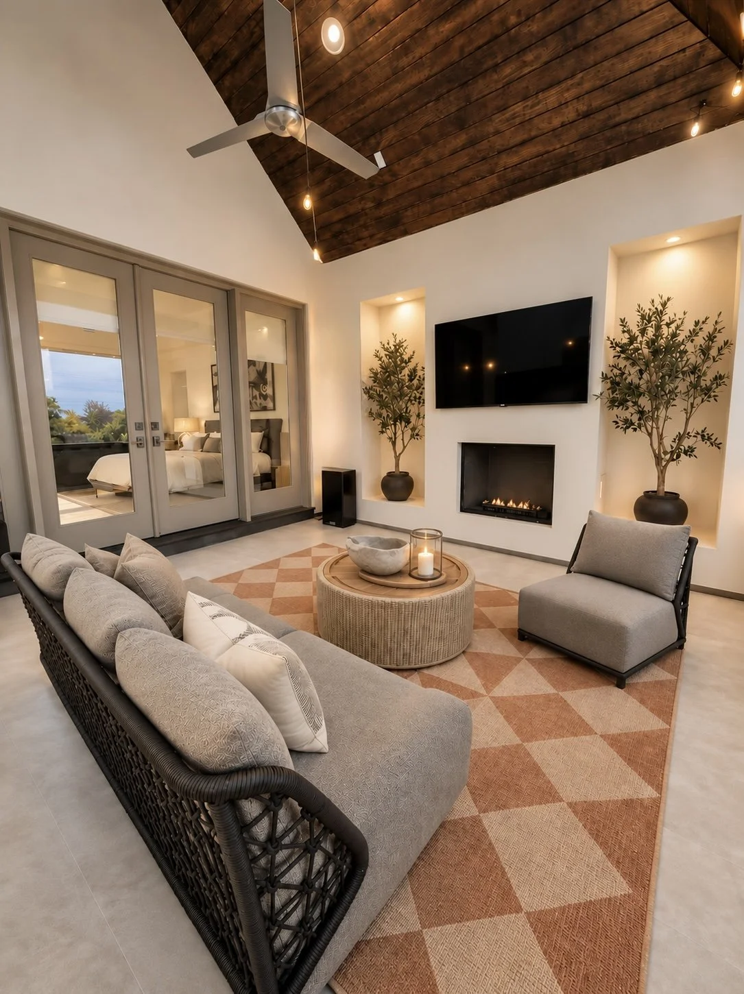 Covered outdoor living area with sectional seating, fireplace, television and warm wood ceiling