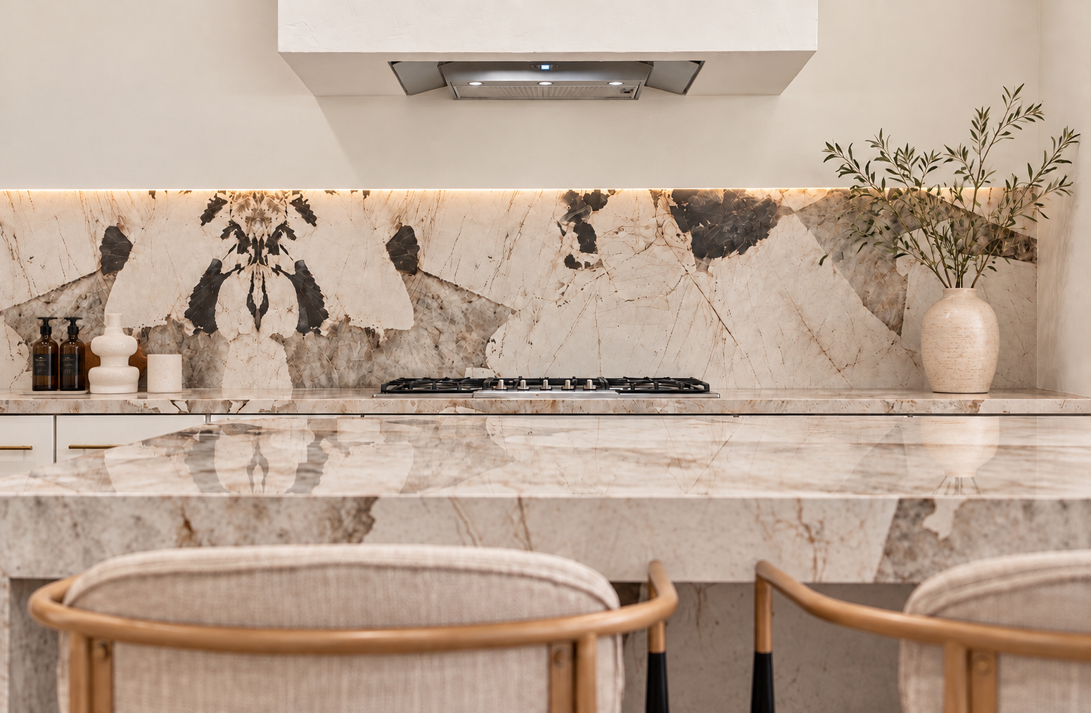 Kitchen detail featuring dramatically veined natural stone backsplash and countertop with warm wood seating.