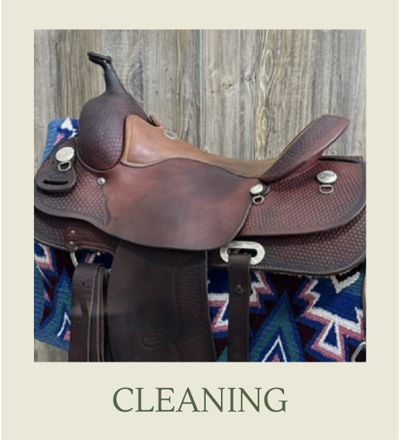 A leather saddle resting on a colorful patterned cloth, with a wooden wall in the background, labeled 'CLEANING'.