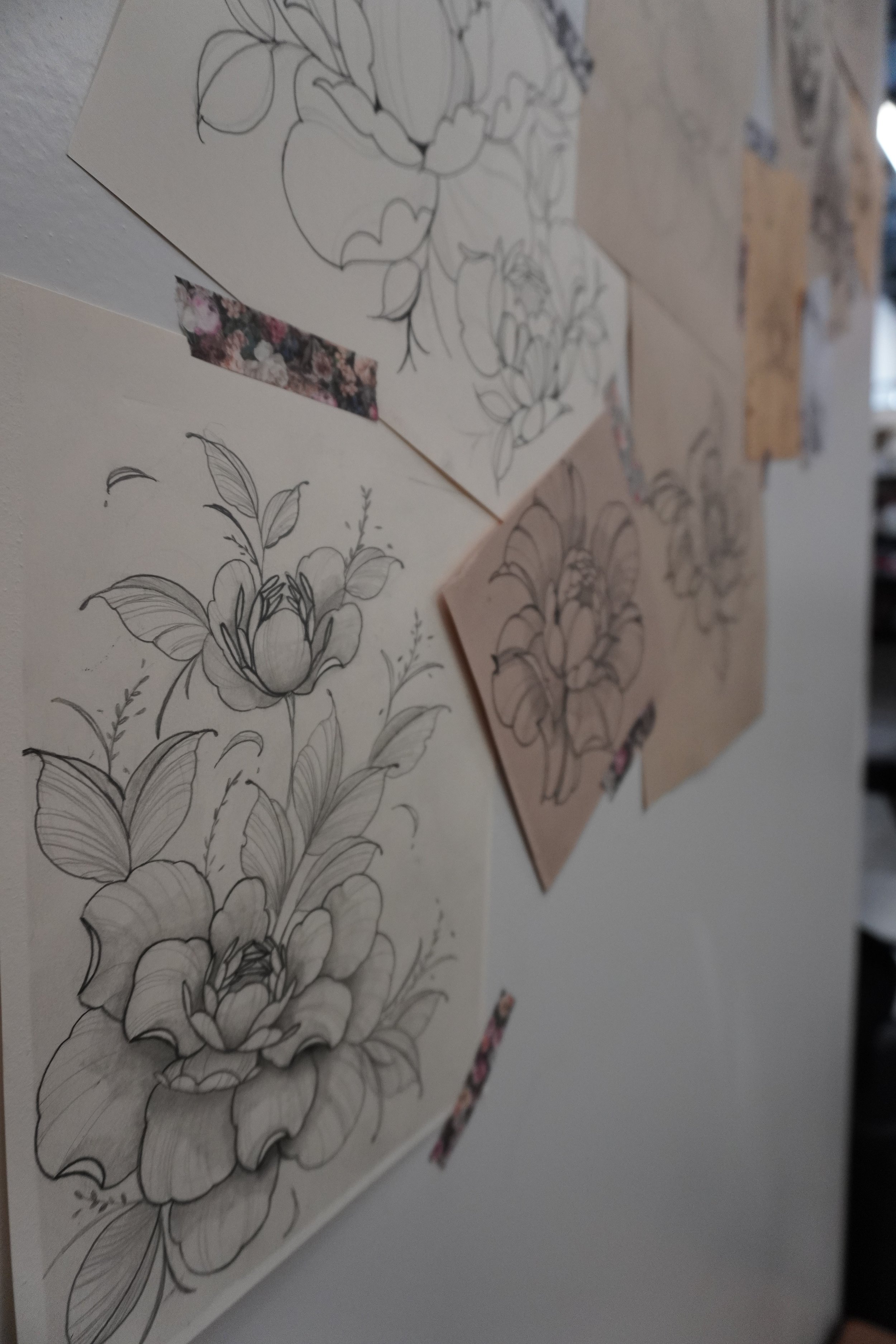 Black and white floral illustration of a blooming flower with detailed petals and leaves.