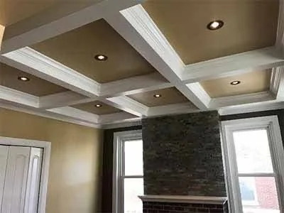 Interior ceiling with recessed lighting and coffered design in a room with large windows.