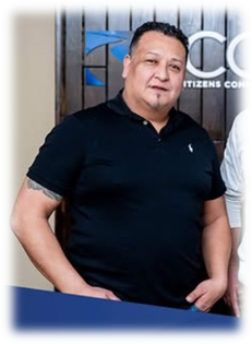 Man in black polo shirt standing indoors