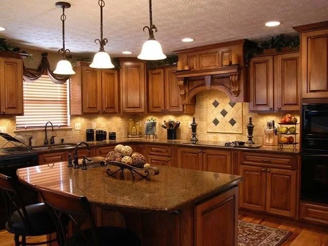 Traditional wooden kitchen with island, pendant lights, window with curtains, and tile backsplash.