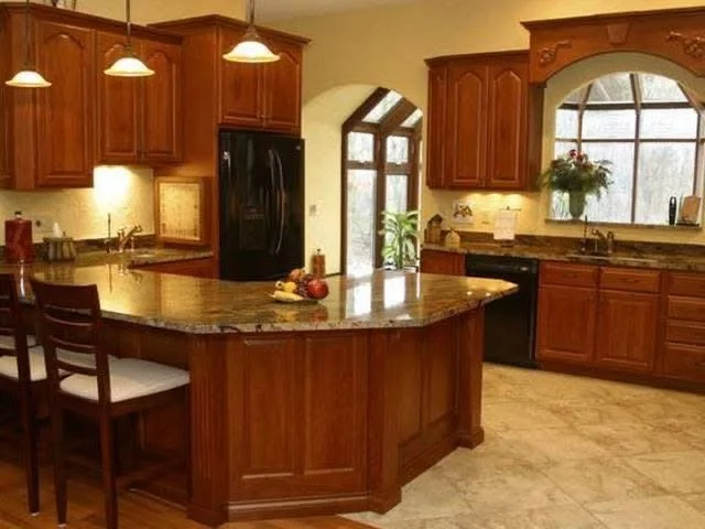 Kitchen with wooden cabinets, a granite island, black appliances, and a large window with a hanging plant.