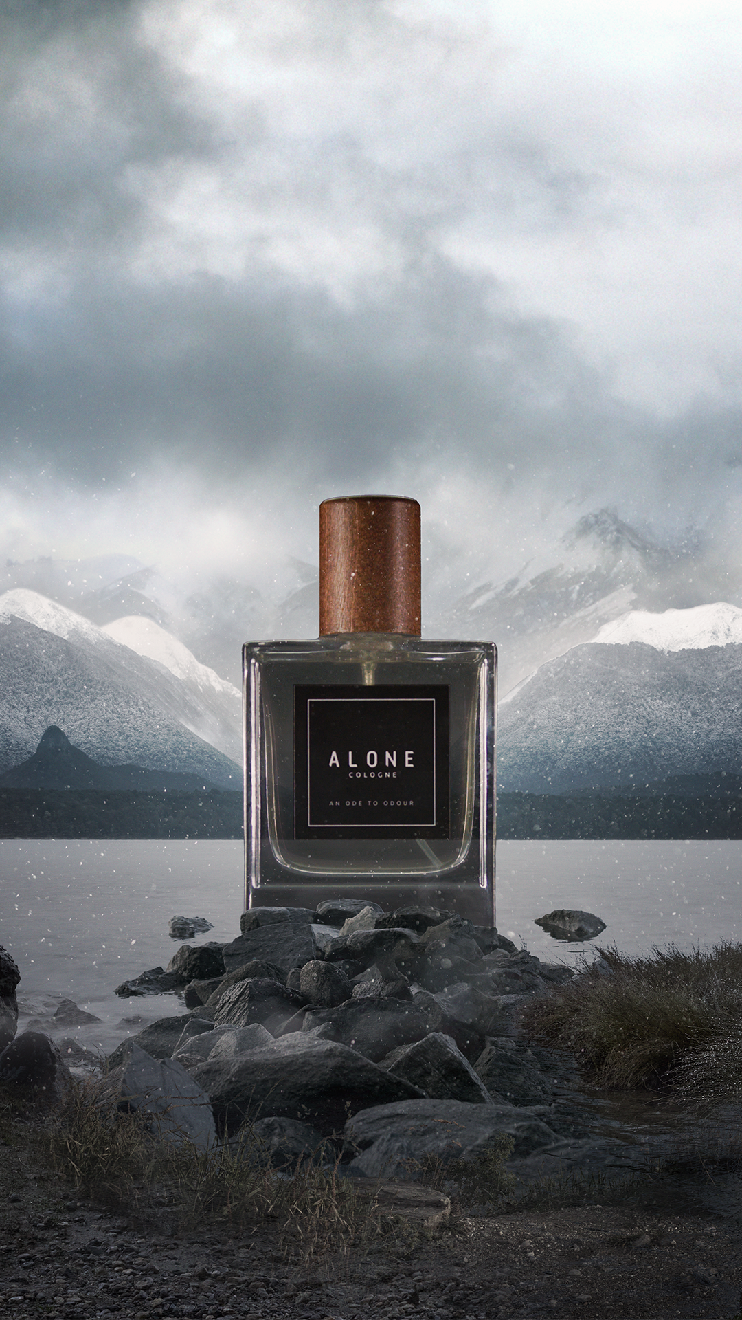 A perfume bottle labeled "Alone Cologne" placed on rocks near a body of water, with mountains and cloudy sky in the background.