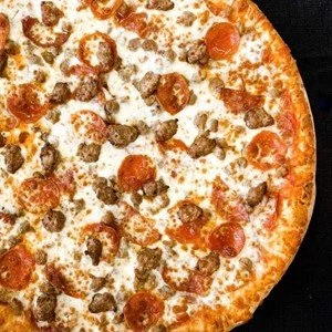 A close-up of a pizza with pepperoni, sausage, and melted cheese.