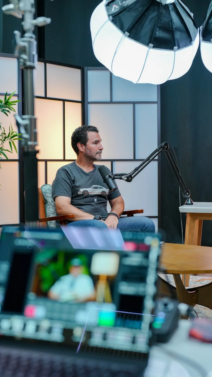 A podcast guest speaking into the mic at Noble Frequency studio in Temecula–Murrieta, with lighting and audio gear in frame.