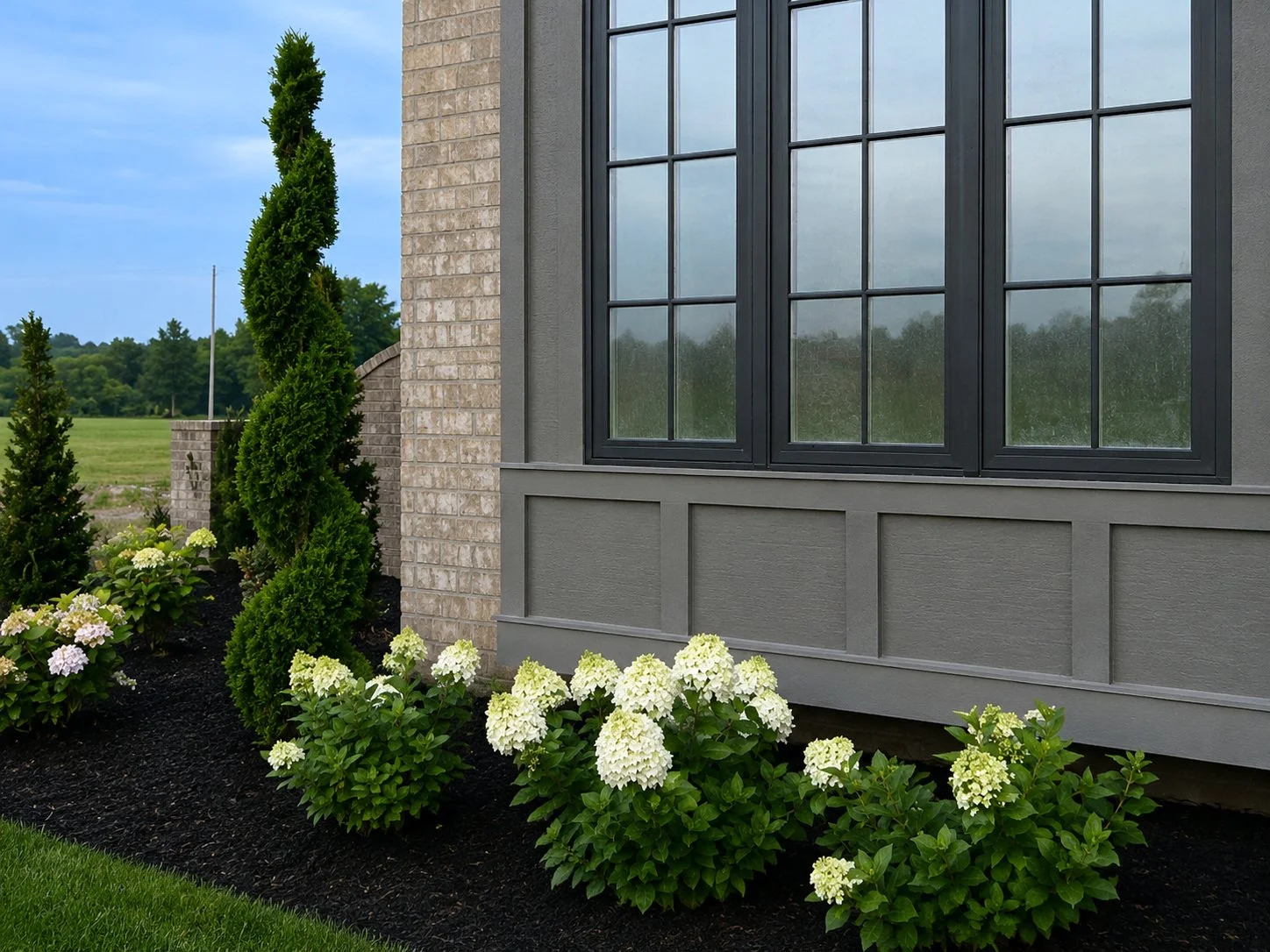 Home exterior detail with a large window and white hydrangeas.