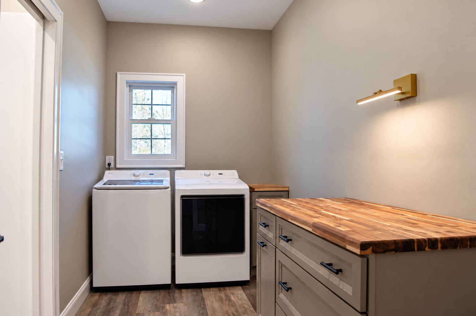 laundry room with a window, appliances, cabinets, and a wood countertop.