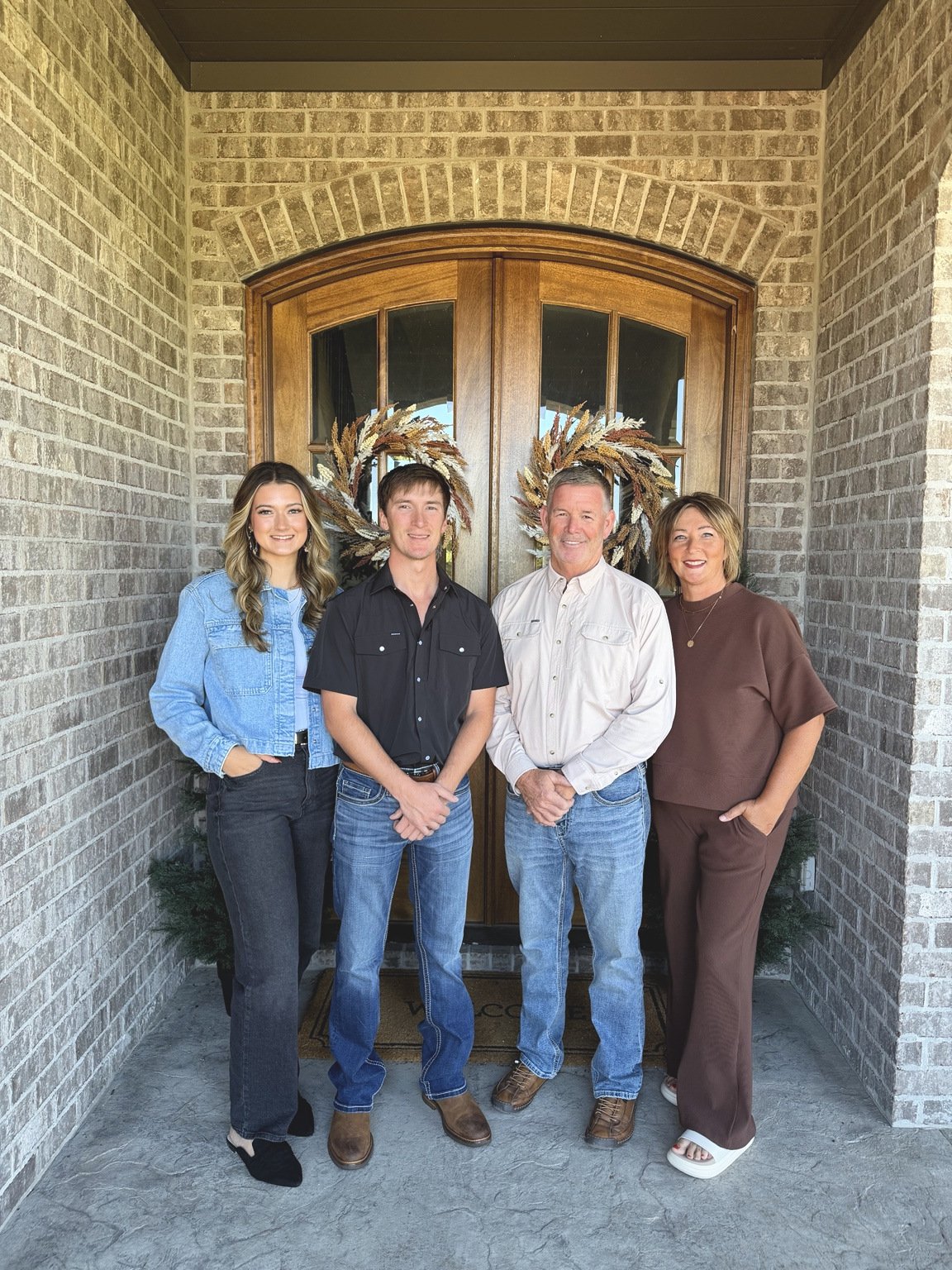 The Qualls Construction team standing together at the entrance of a home.