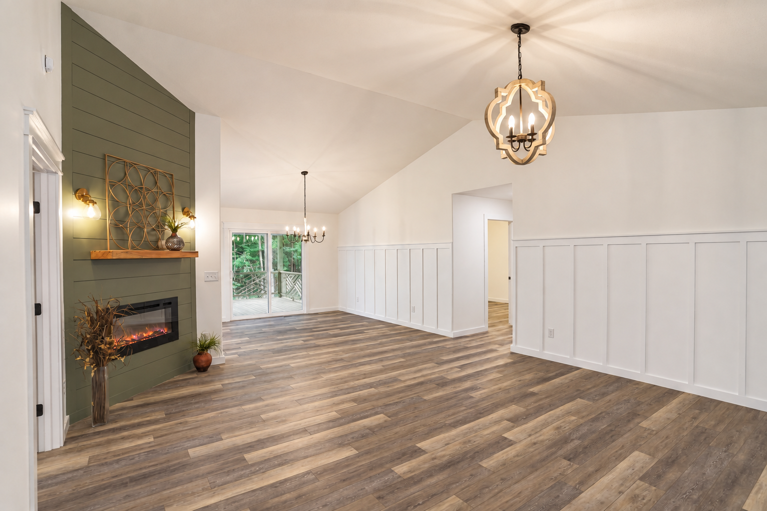 Open living room with wood flooring, white paneled walls, and a green accent wall.
