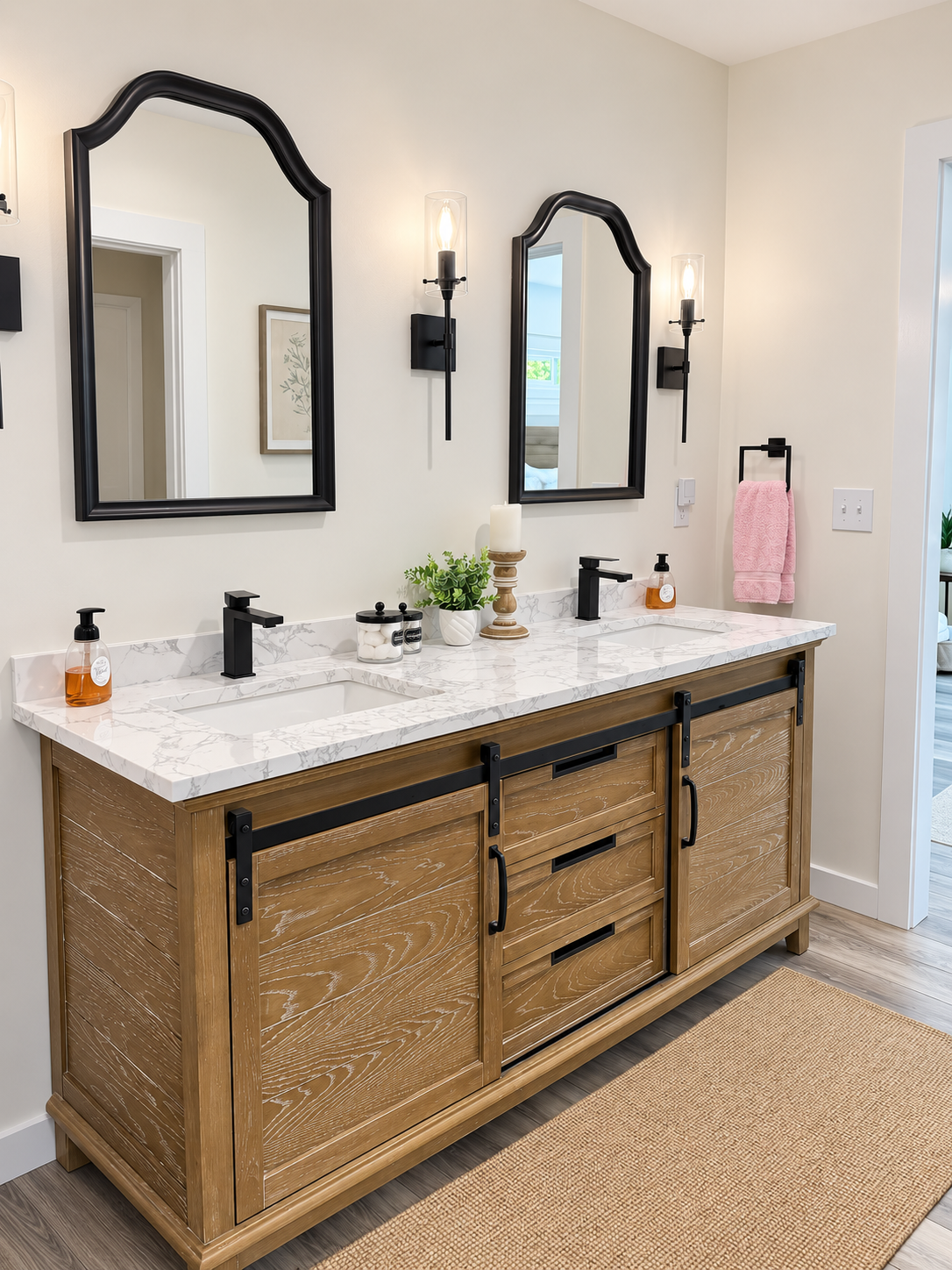 Double sink bathroom vanity with wood cabinets, black framed mirrors, and wall sconces.
