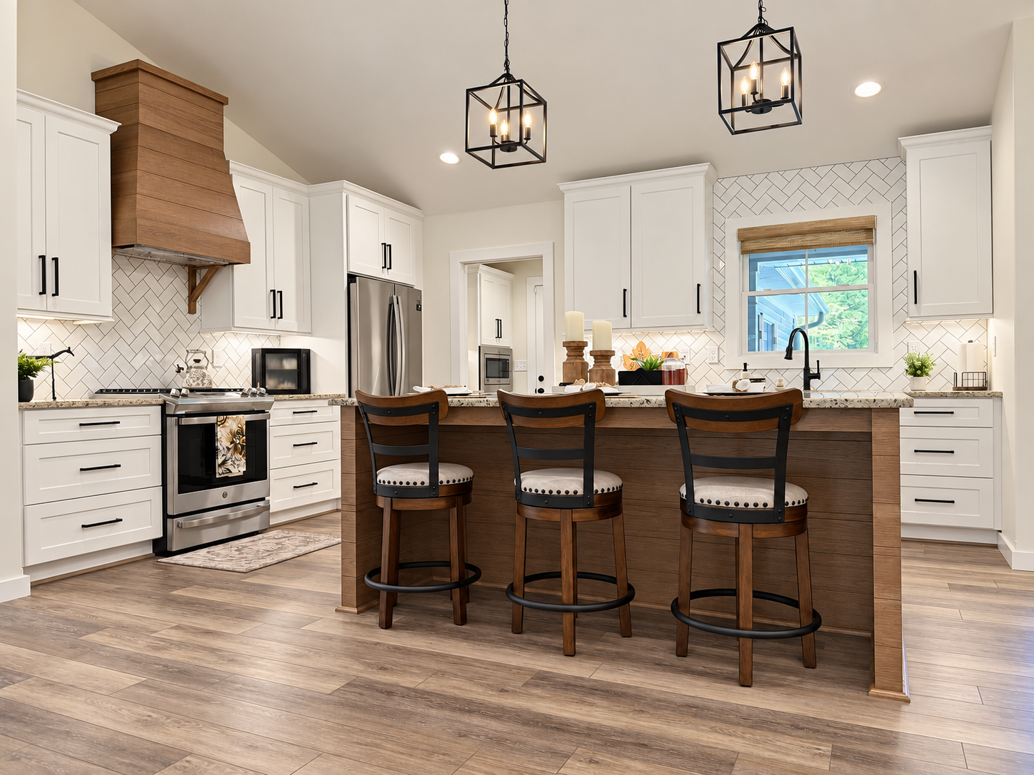 Modern kitchen with white cabinets, a wooden island with three chairs, black hardware, a stainless steel fridge, and two black pendant lights