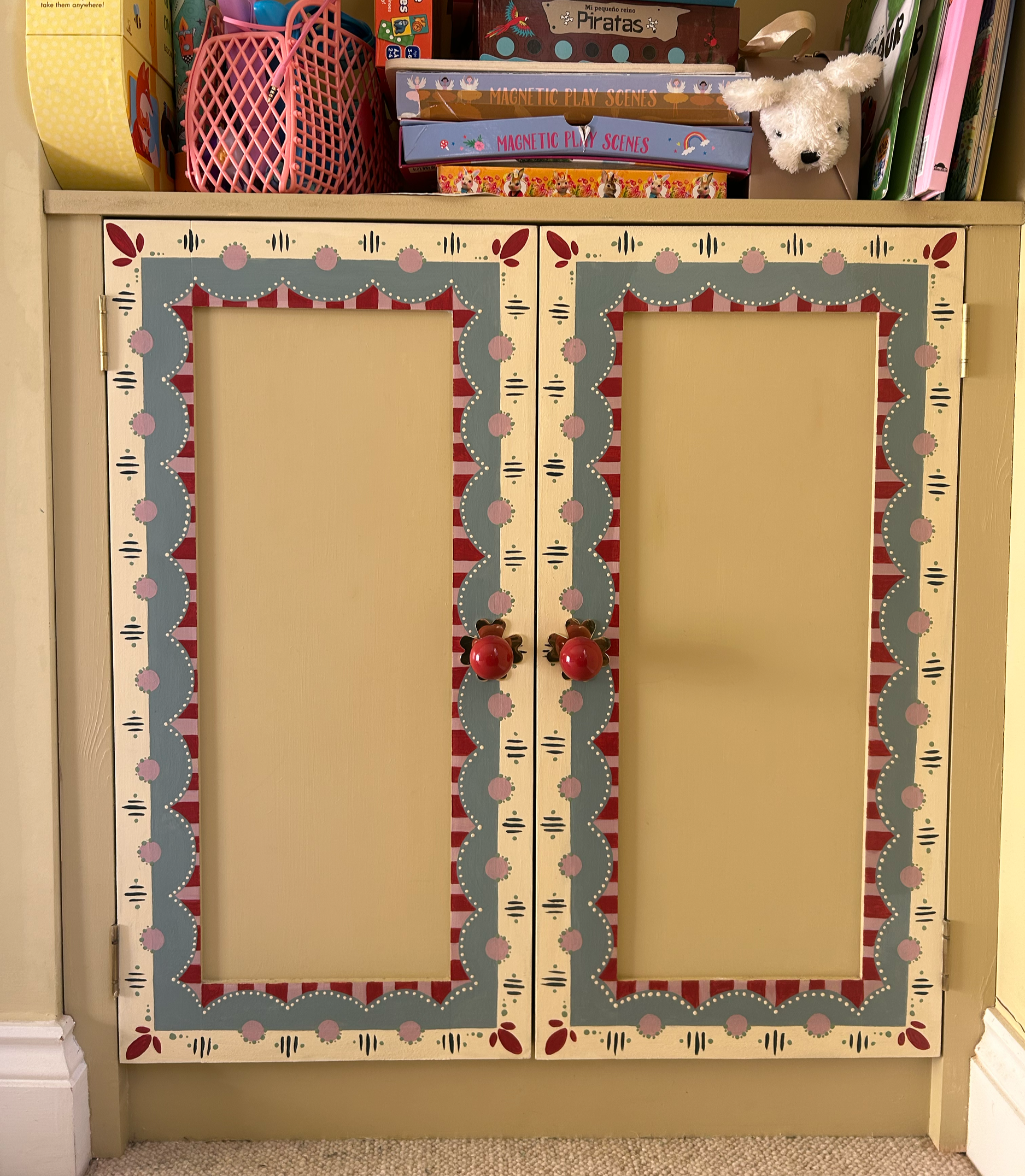 Hand painted cupboard border design to tie in with previous custom painting of a fireplace area.