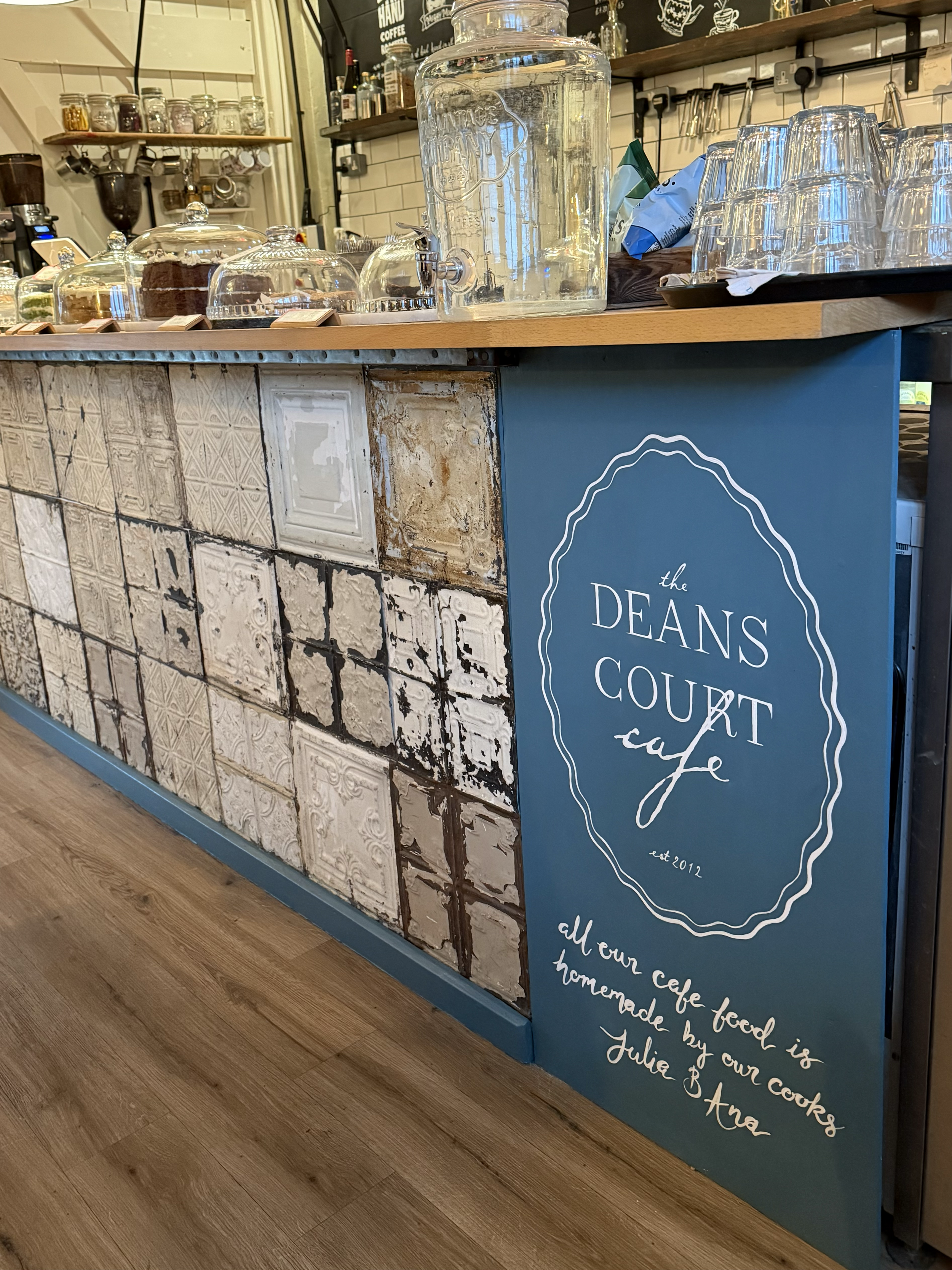 Hand painted logo (also designed by me) and text underneath for Deans Court Cafe, Wimborne.