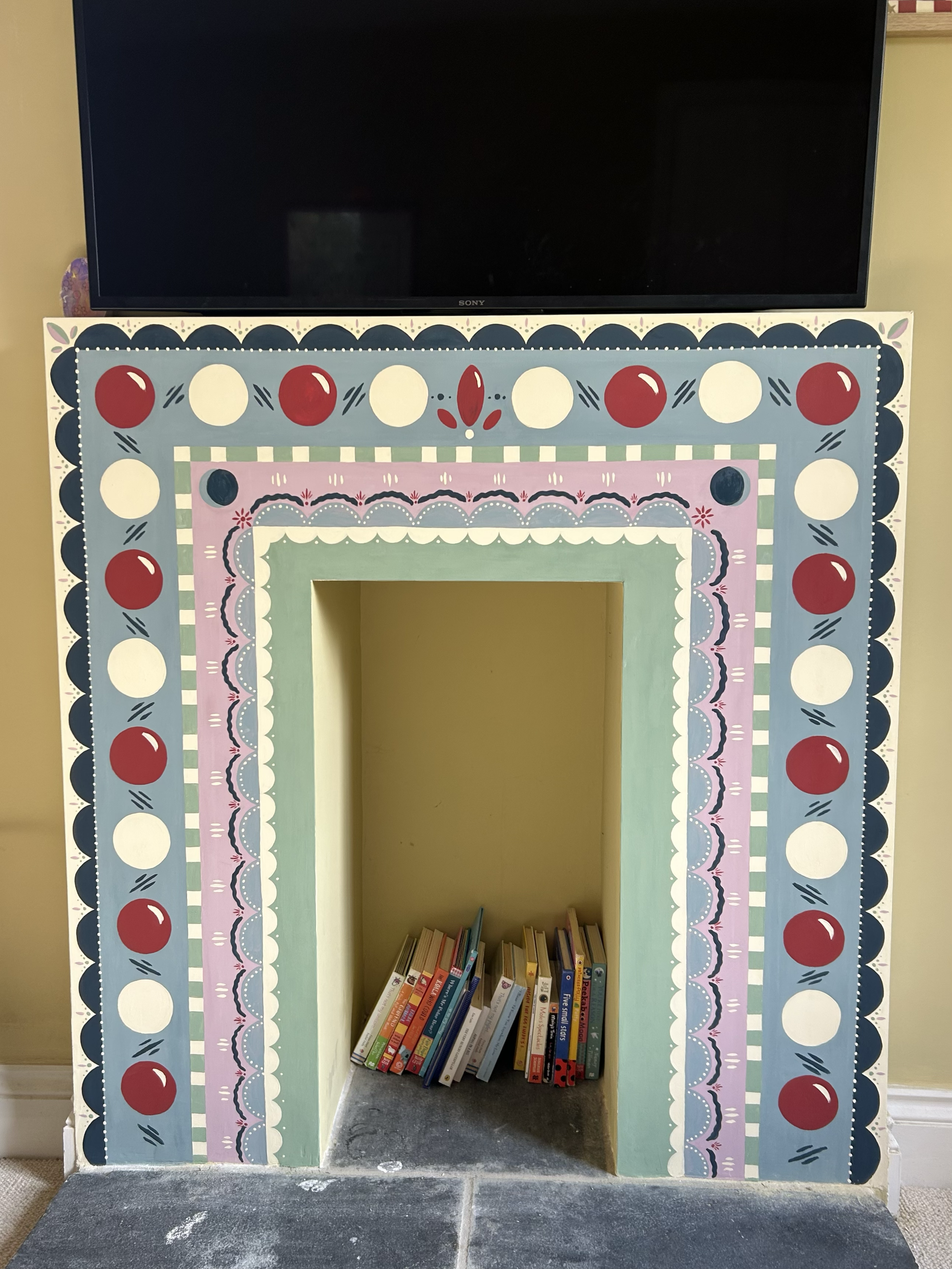 Bespoke hand painted fireplace design for kids playroom project.