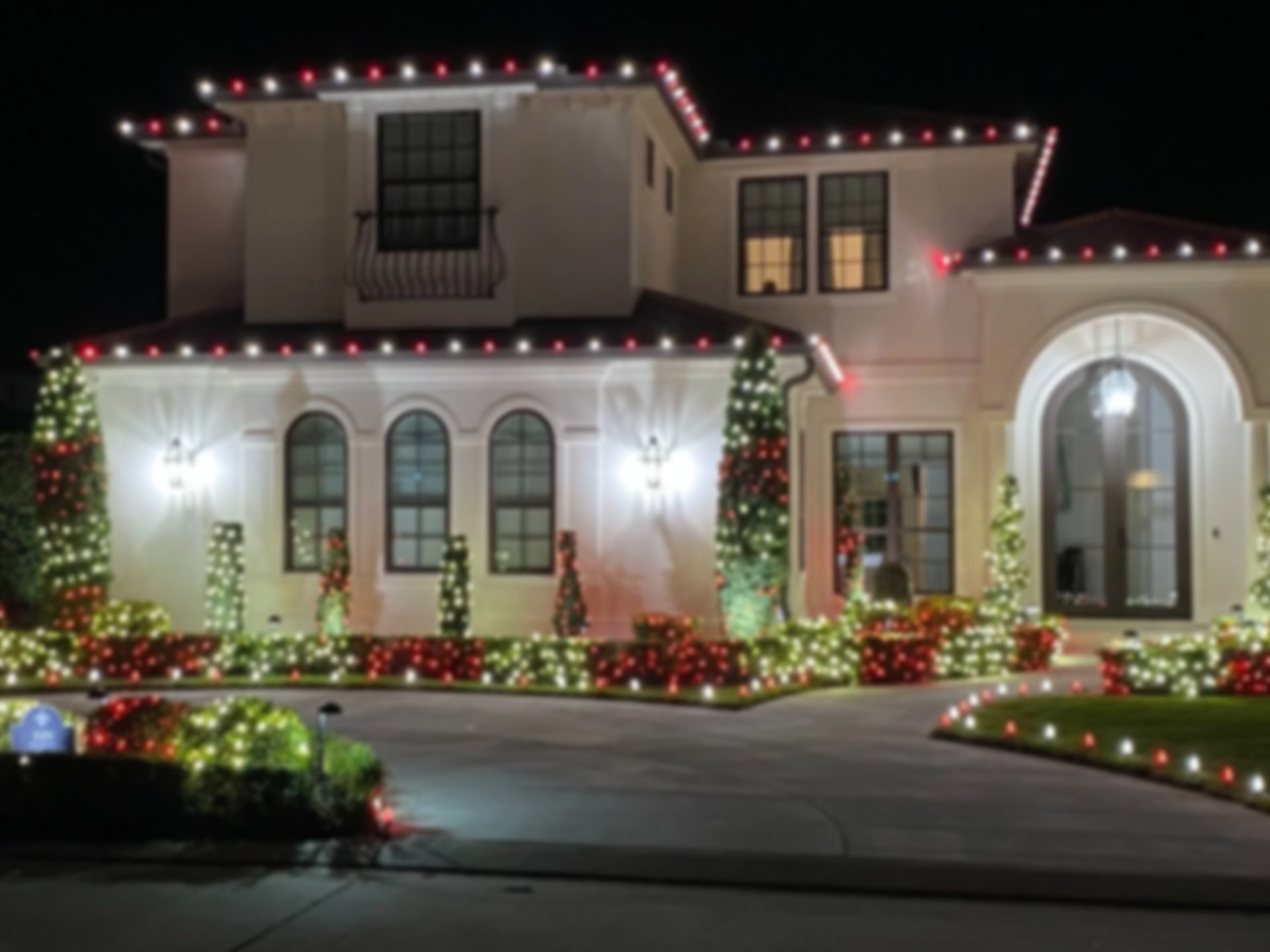 Top-rated holiday light installation lighting up trees and shrubs on an Orlando home