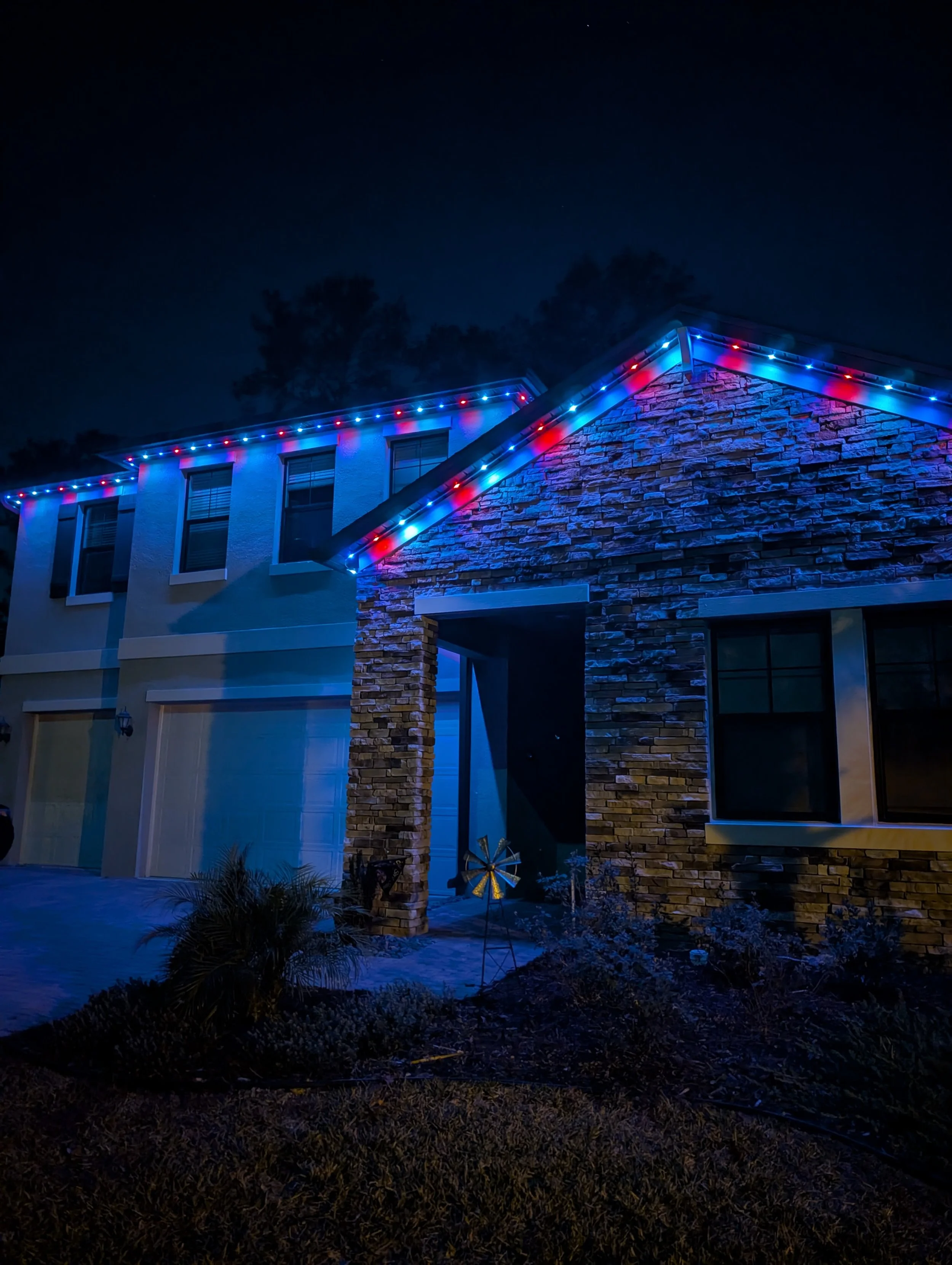 Permanent LED roofline lighting installed on a home at night in red and blue. Orlando Permanent Lighting, Winter Park Holiday Lighting, Windermere Christmas Light Installation Near Me