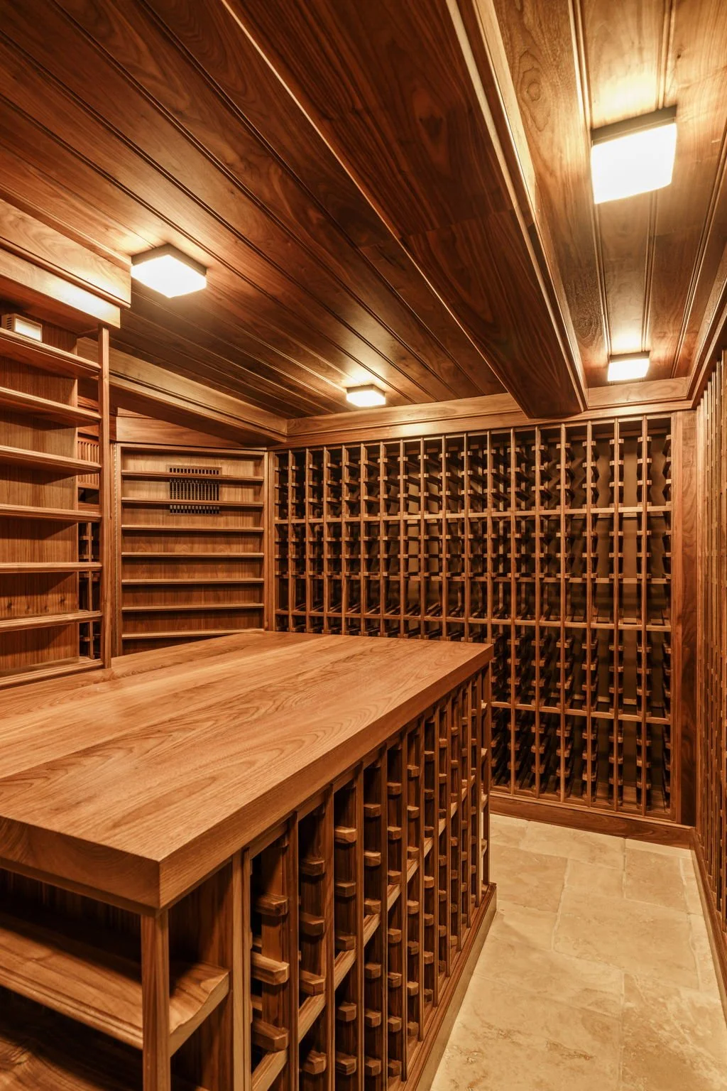 A wooden wine cellar with shelves and a wine rack, illuminated by ceiling lights.