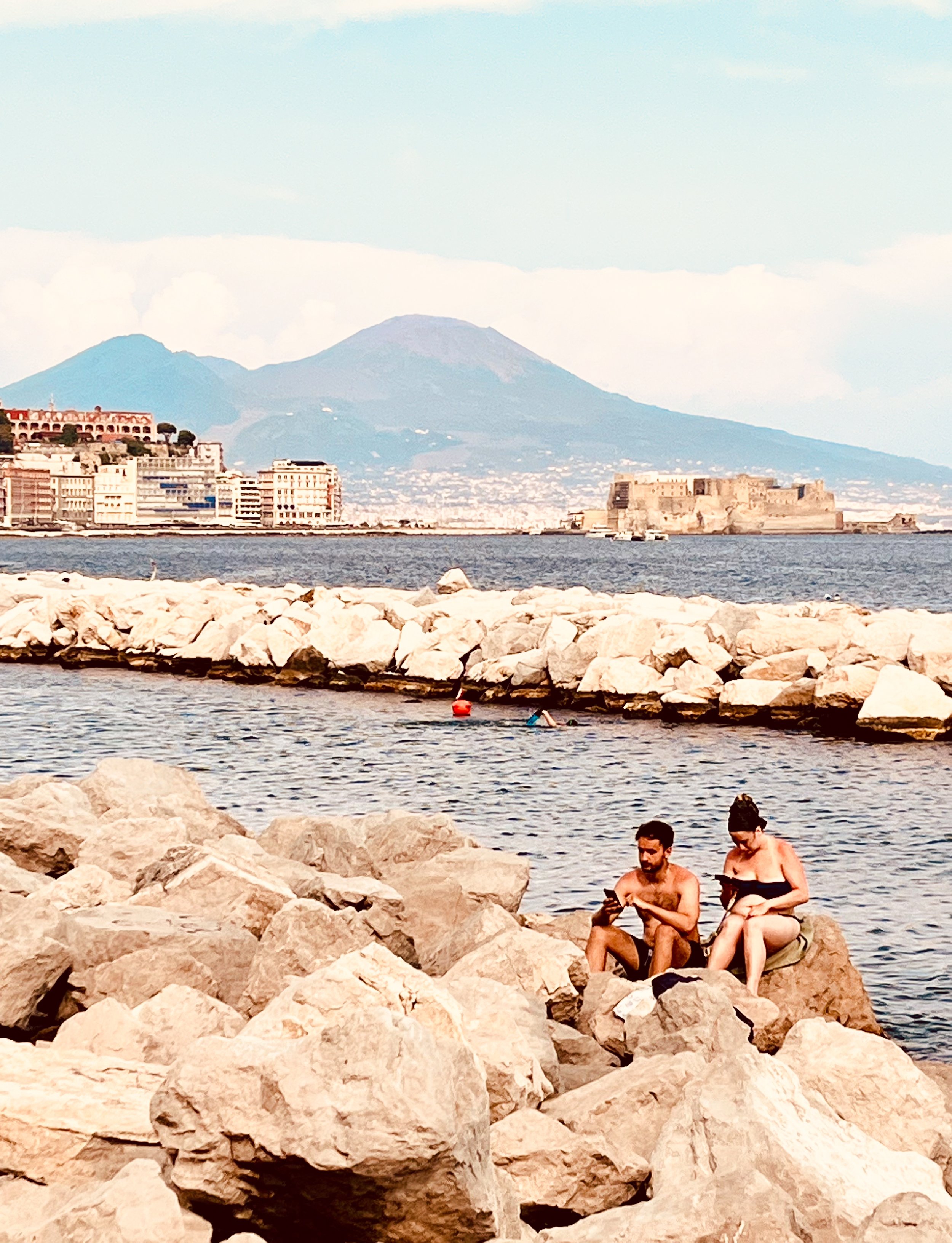 Lovers enjoy the seaside in Napoli's Mergellina neighbhour, while Mount Vesuvio looks over the city. Napoli is a must-do on any central Italian itineraries.