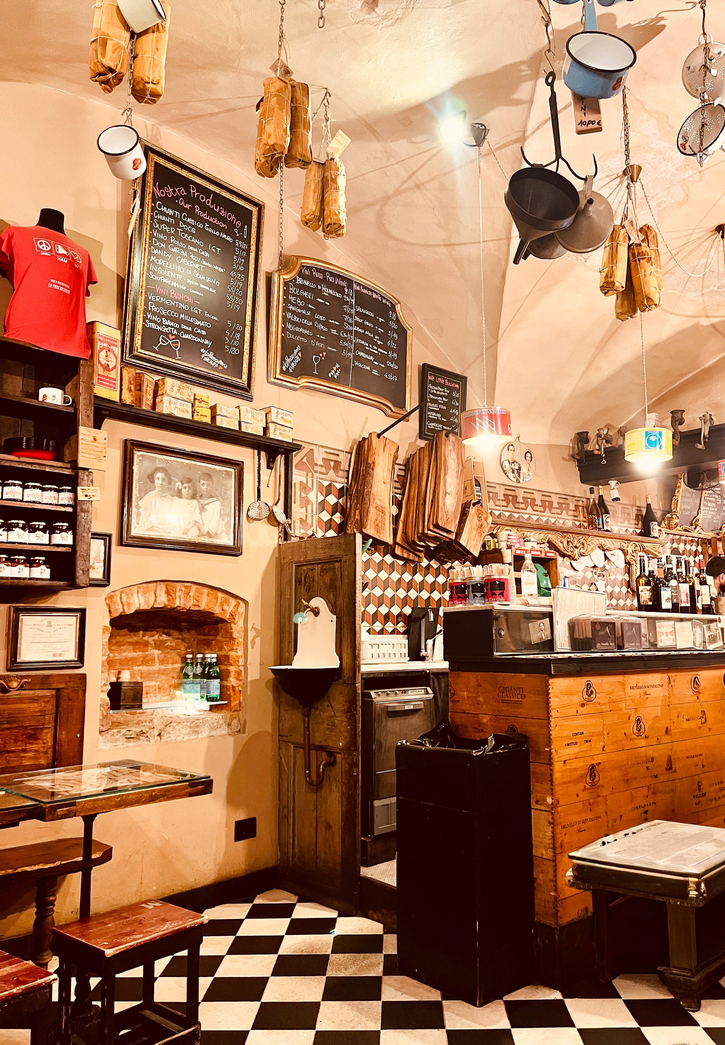 When in Florence, a panini with a glass of wine for lunch is must. The interior of this shop has wooden furniture, black and white checkered floor, and decorative hanging pots and bags from the ceiling.