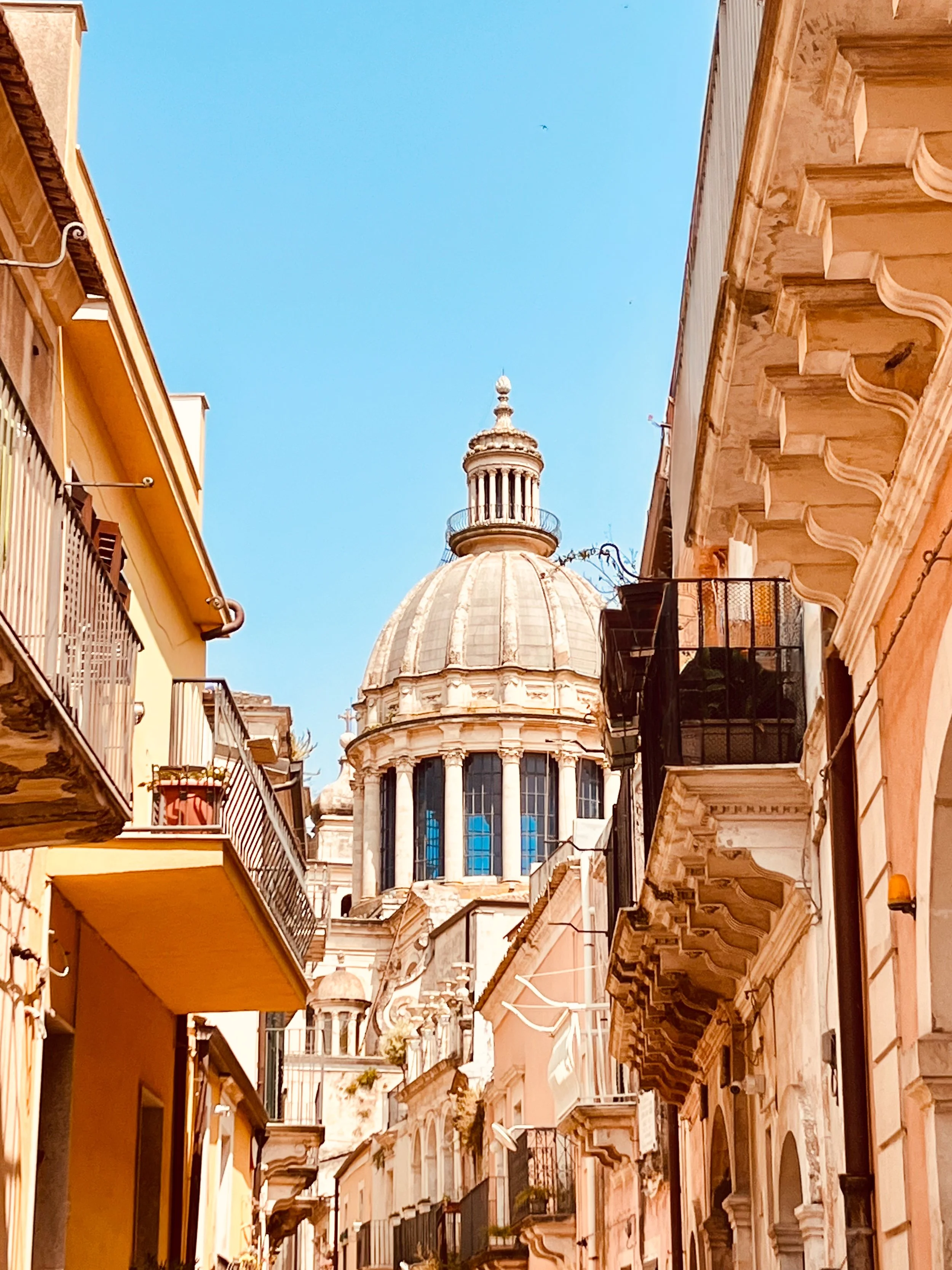 An alleyway in the baroque hilltop city of Ragusa in Sicily, with the Duomo San Giorgio in the background. Il Paradiso can help you plan Ragusa into your Sicilian itinerary.
