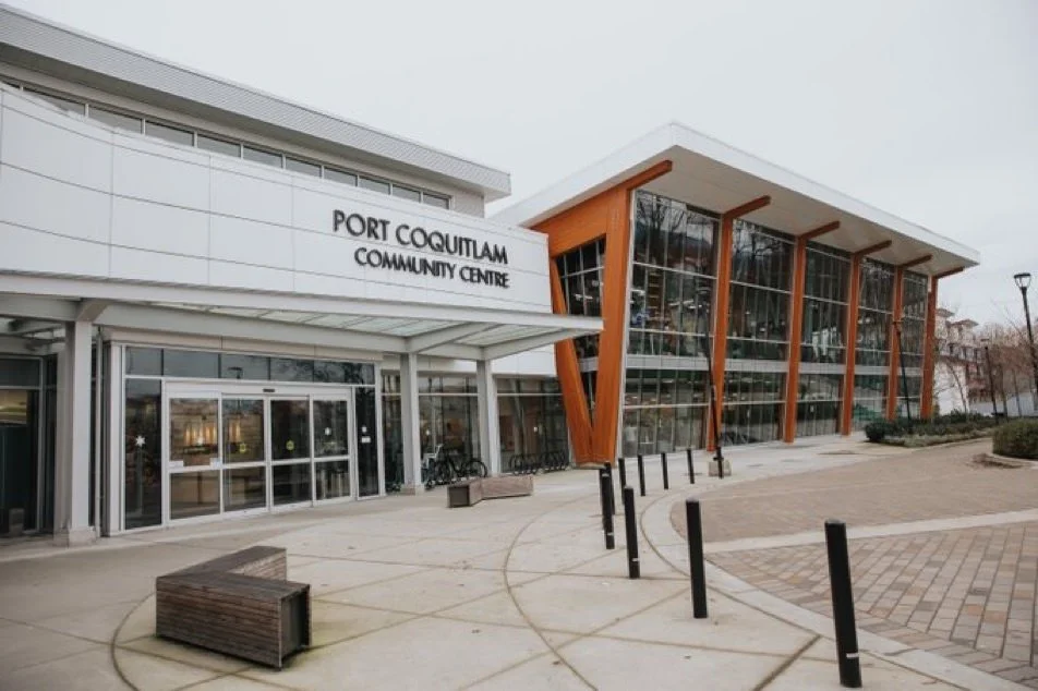 Exterior of Port Coquitlam Community Centre with modern architecture, large glass windows, and wooden accents.