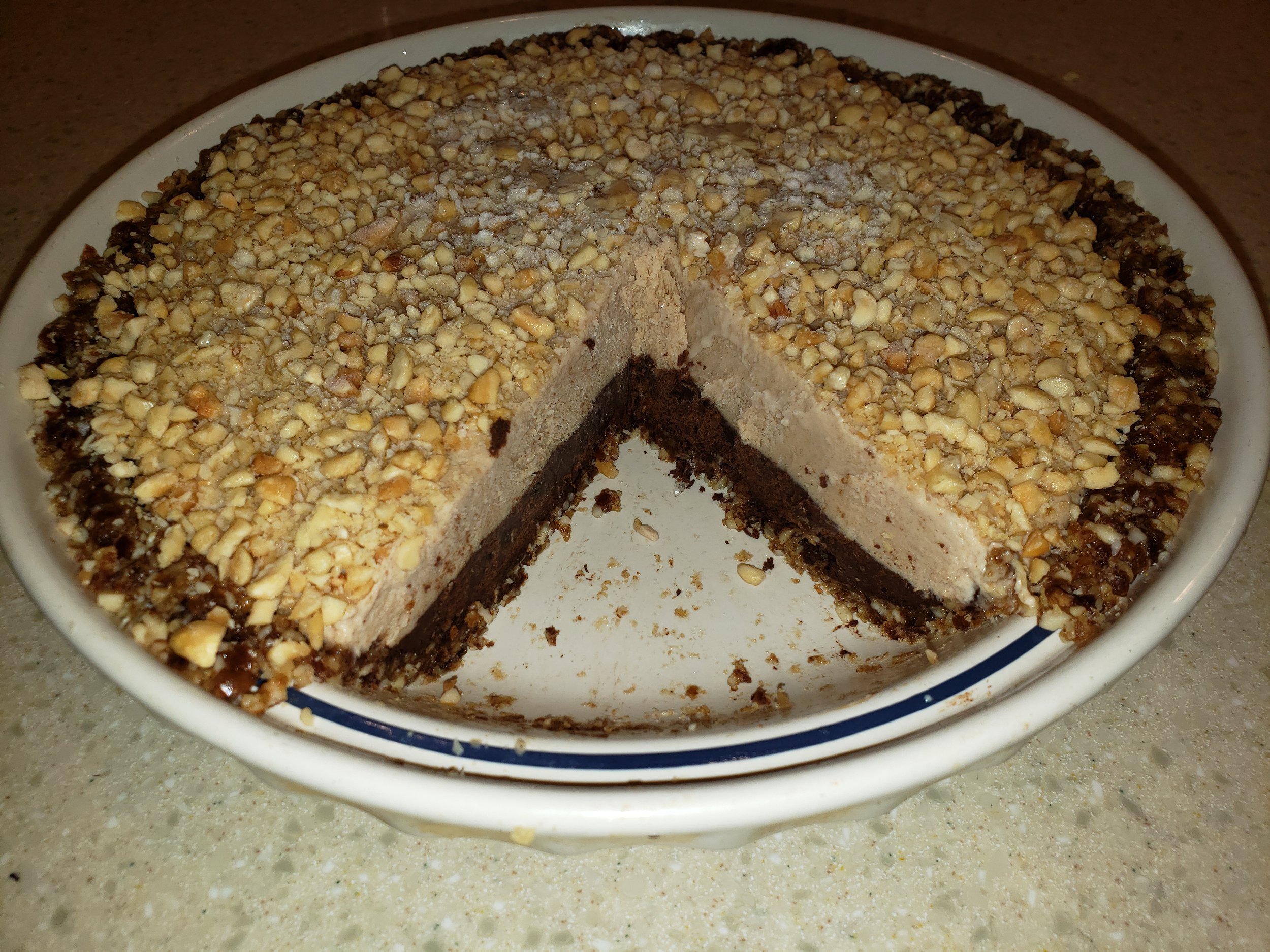 Whole-food, plant-based chocolate peanut butter pie made from nuts, dates, tofu, peanut butter, and cacao.