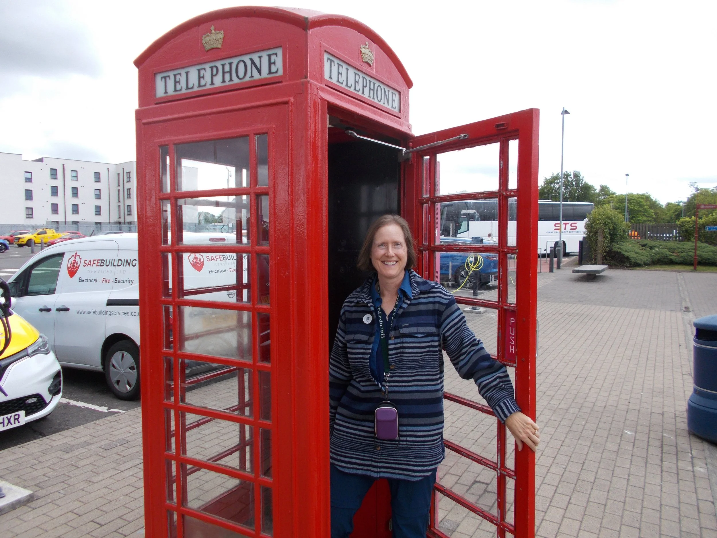 Amy inside a red British telephone booth during a cruise excursion.