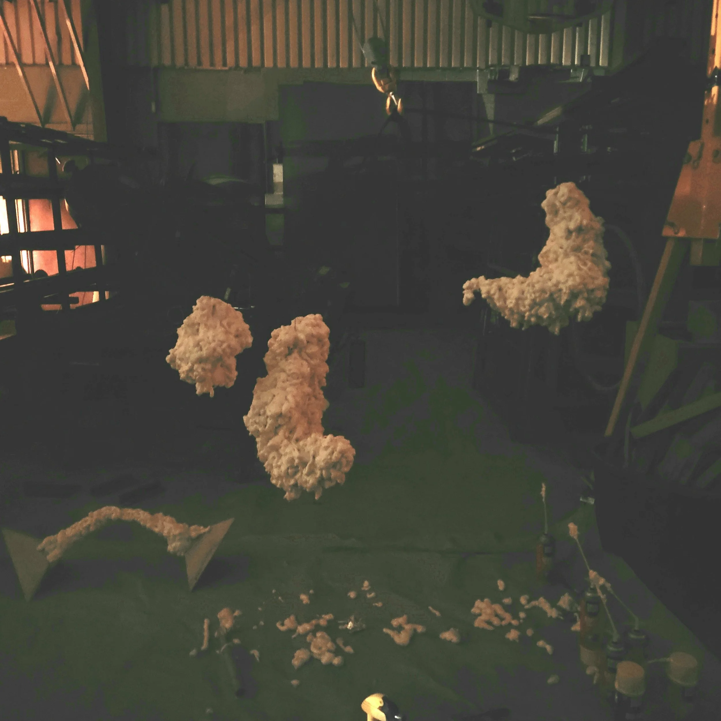 Sculpture process image of spray foam suspended in an industrial setting to dry. 