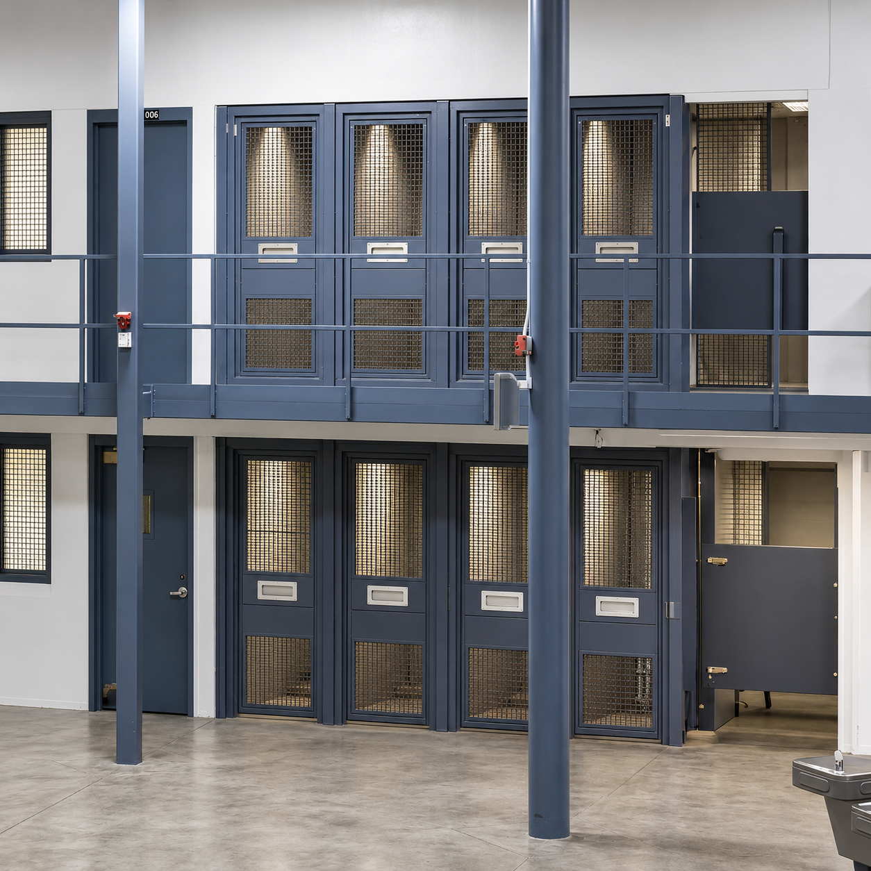 Shower cages at USP Terre Haute High Security. The shower cages are on both tiers. They have lockable doors with thick wire mess so that it is easy to see into the shower stall.