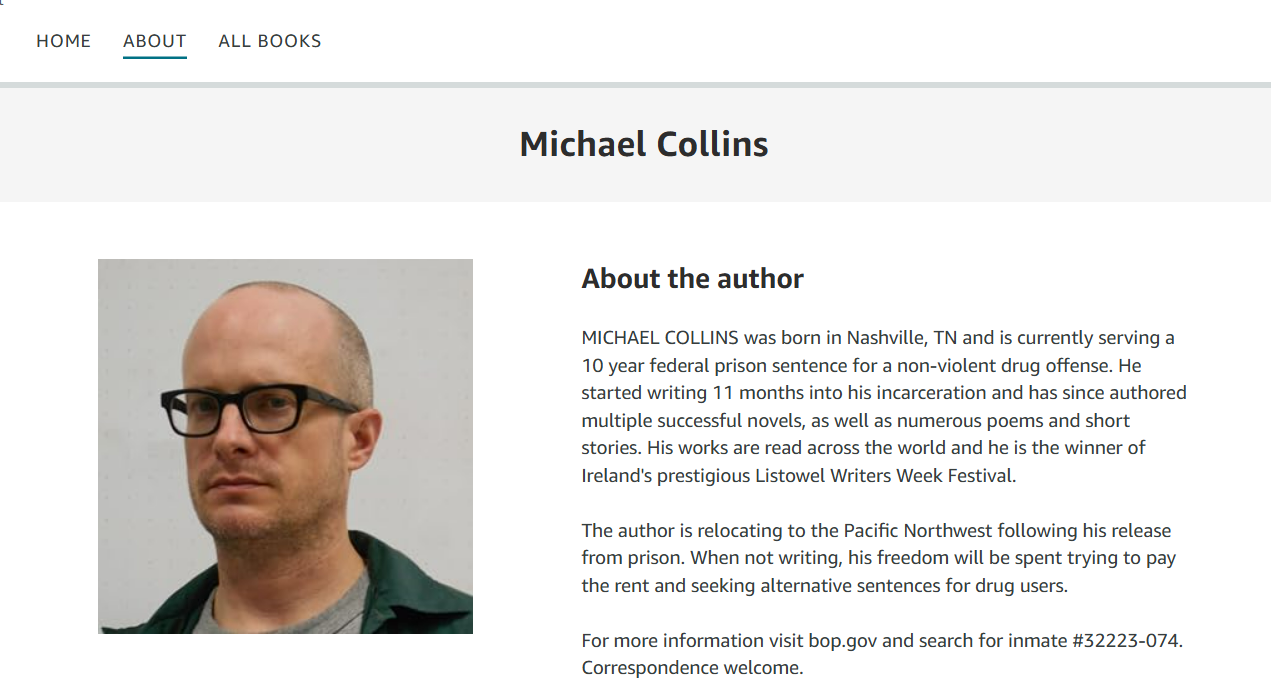 Photograph of Michael Collins, a man wearing glasses and a dark green shirt, with a bald head and serious expression.
