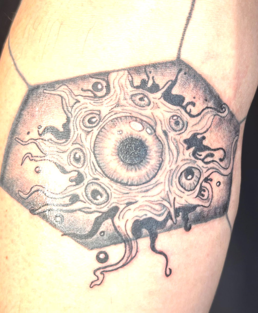 Tattoo of an eye with abstract swirling patterns surrounding it.