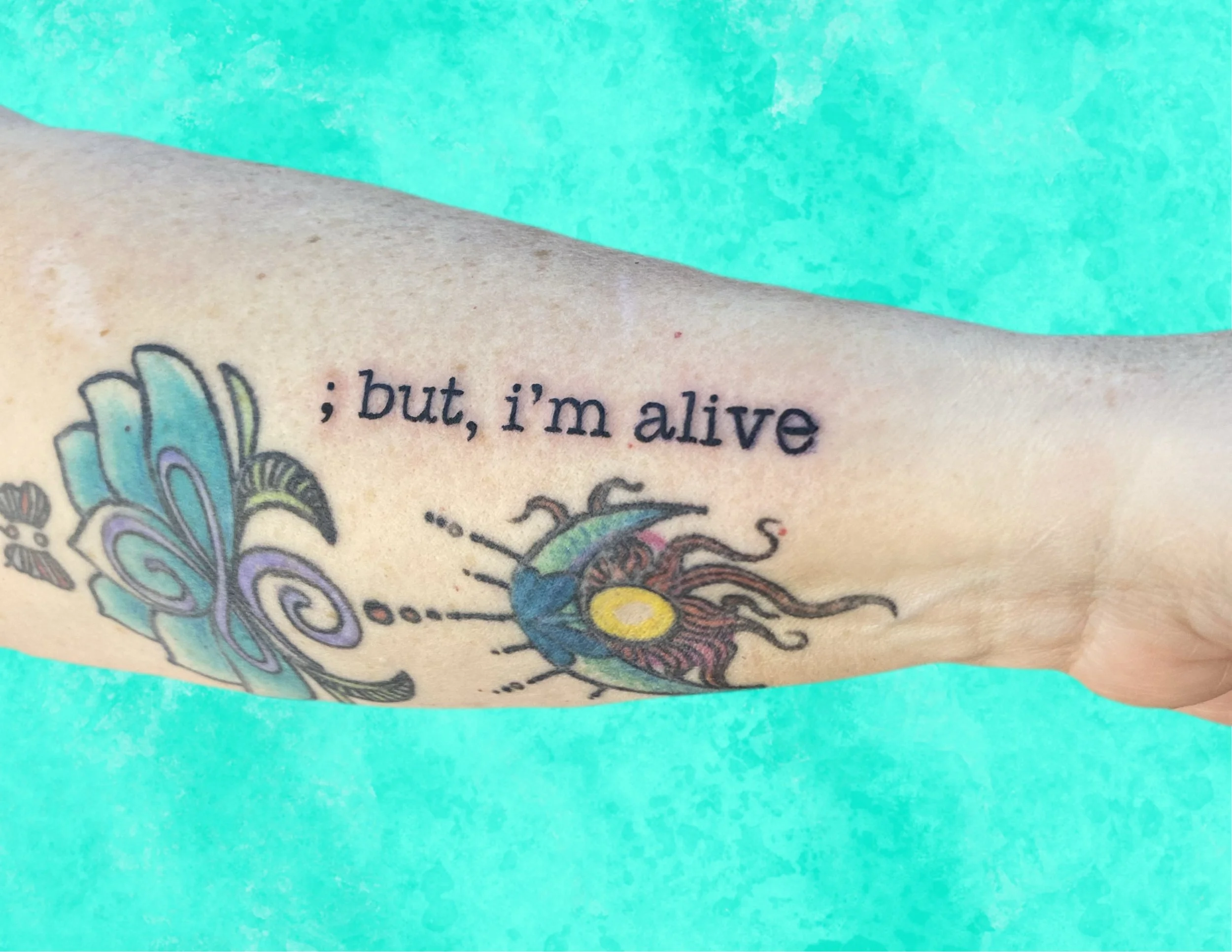 Close-up of a tattoo featuring vibrant colors and intricate details, with partial readable text.