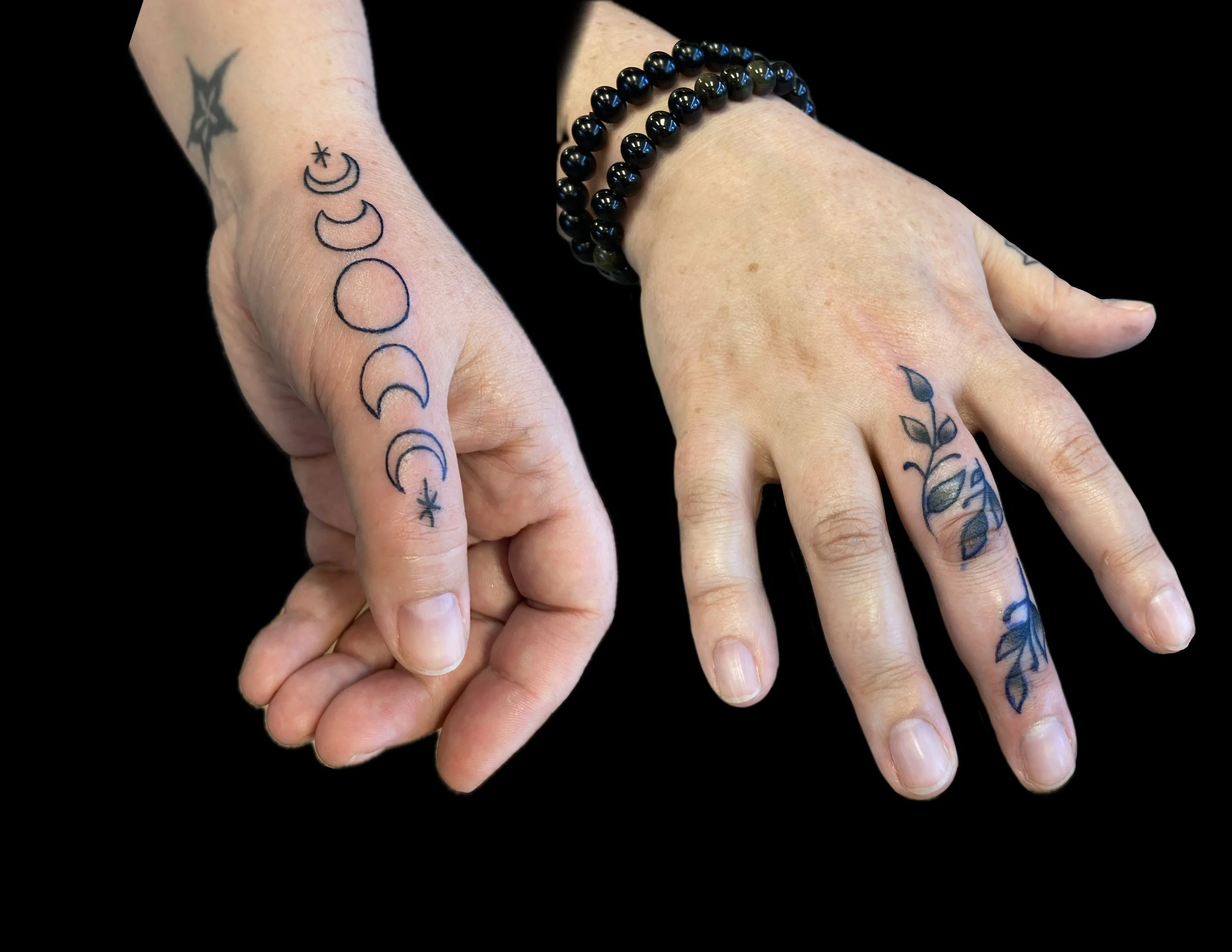 Close-up of two hands with tattoos, one wearing layered black bead bracelets.
