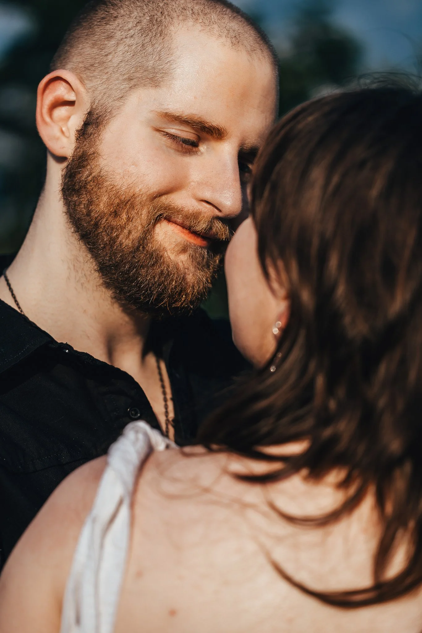 A close-up of a man and woman sharing an intimate moment, with their faces close together and eyes closed.