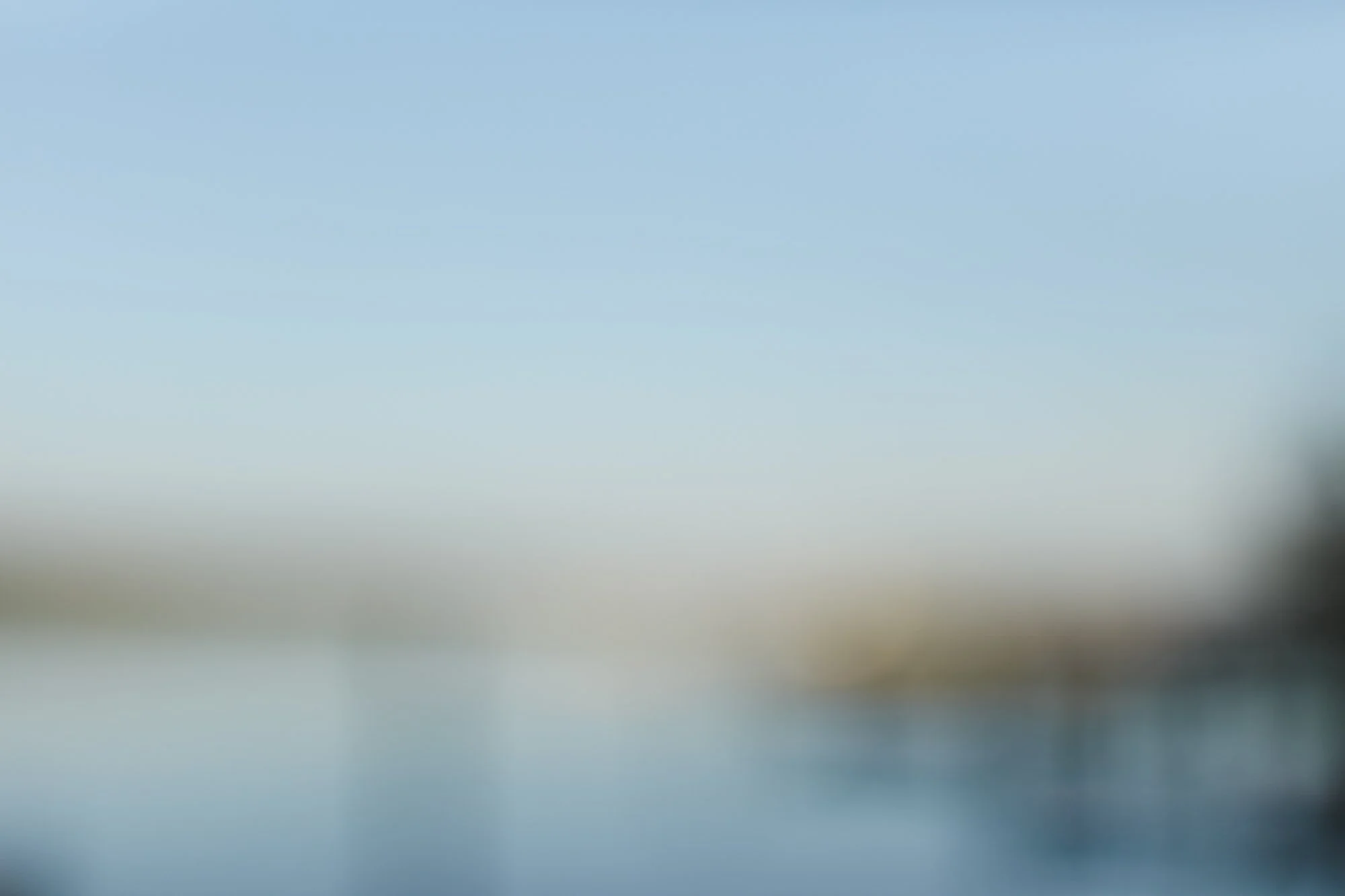 Blurred image with blue and green hues, possibly depicting an abstract or distant scene.