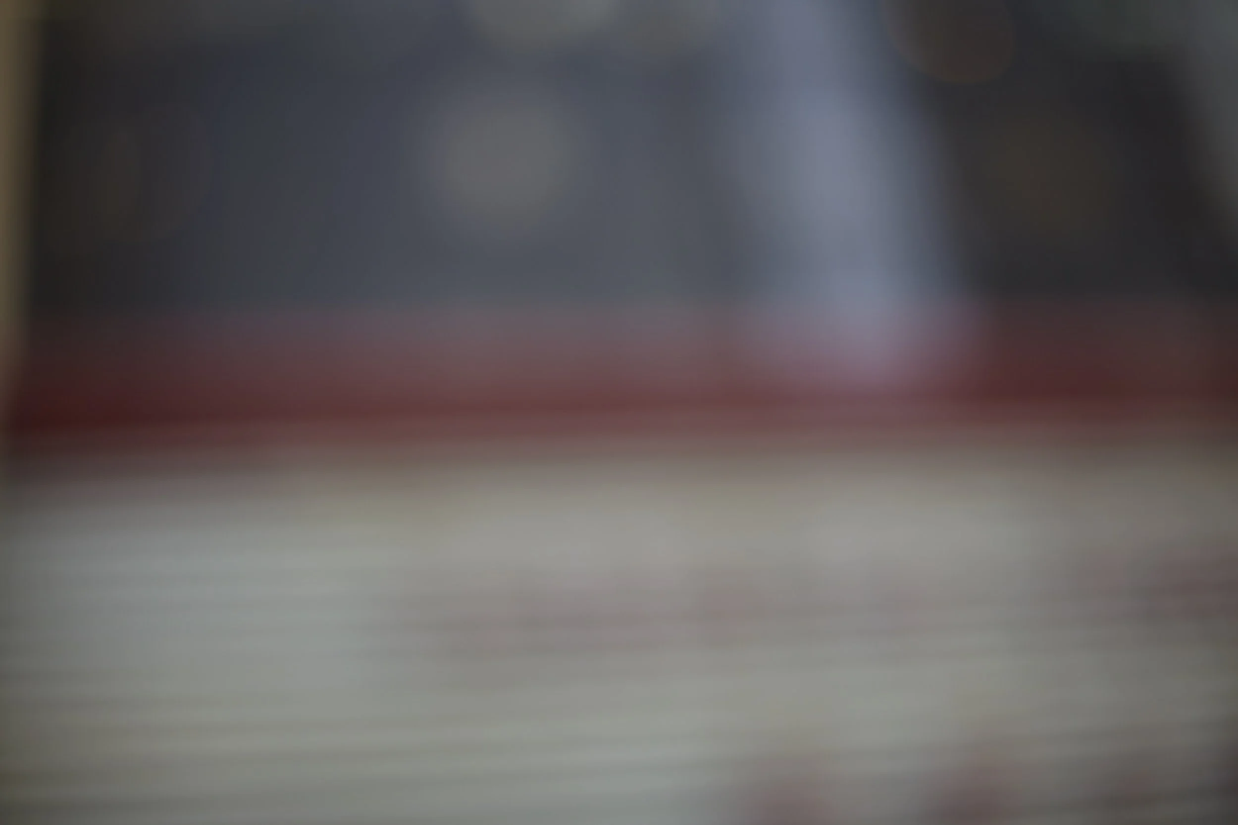 Blurred image with dark and light areas, no clear objects or details visible.