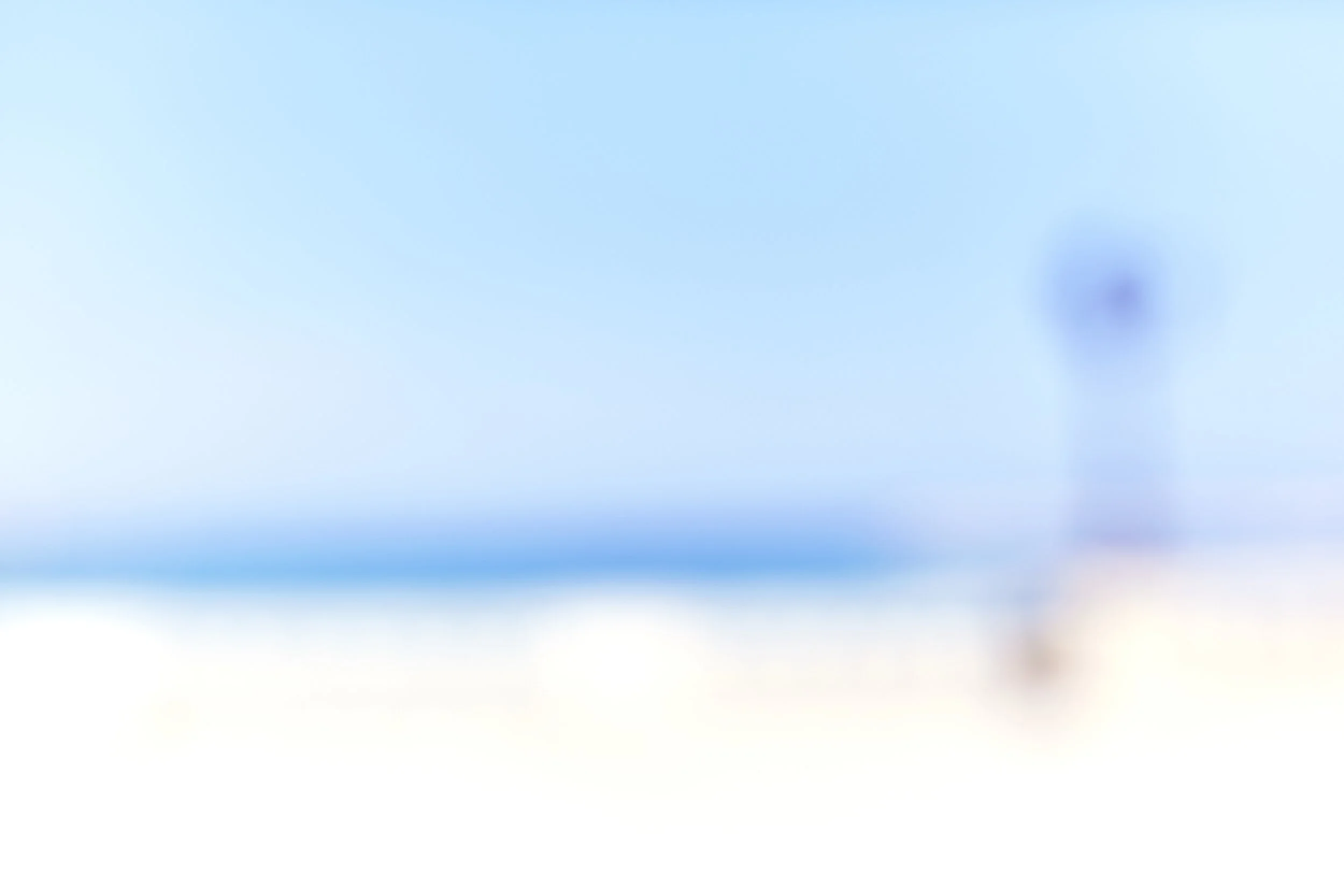 A blurry image with shades of blue, white, and some dark spots.
