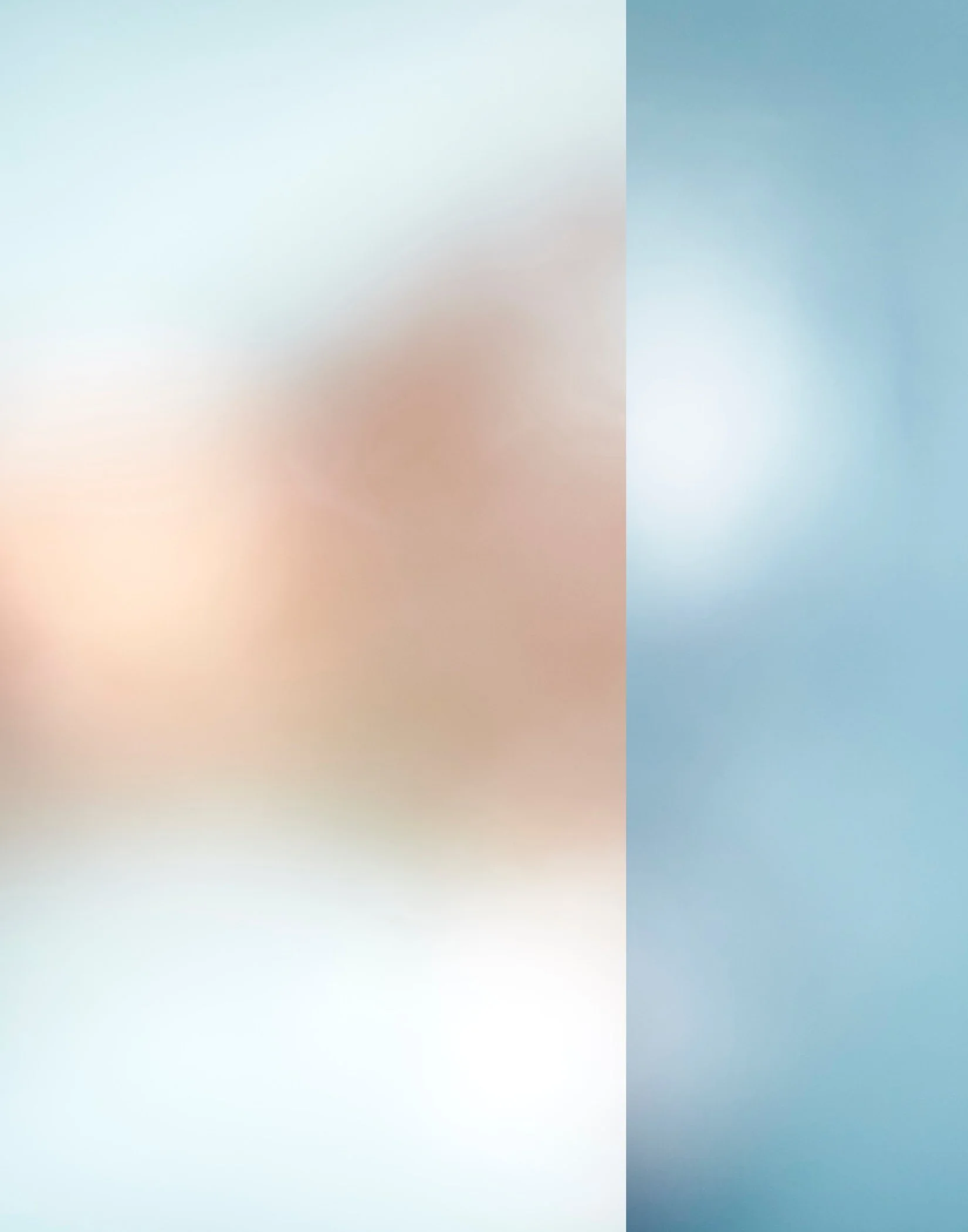 Blurred and abstract image with soft pastel colors, including shades of blue, peach, and cream, with no specific objects or details clearly visible.